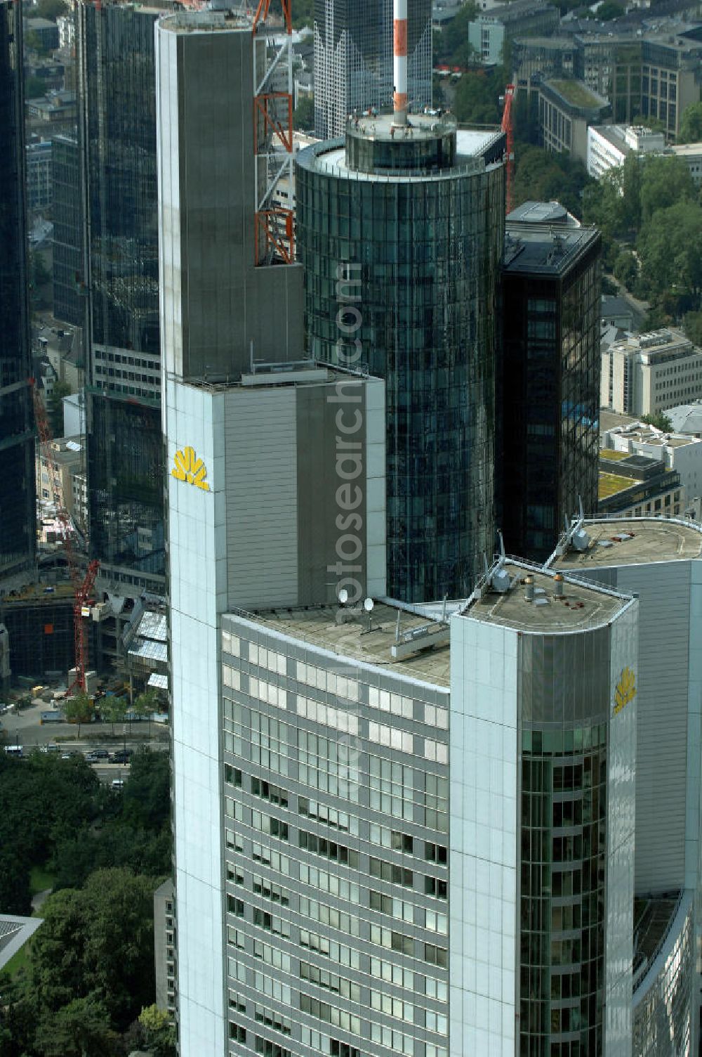 Aerial photograph Frankfurt am Main - Blick auf den Commerzbank Tower, er ist ein bekannter Wolkenkratzer in der Innenstadt von Frankfurt am Main. Mit einer strukturellen Höhe von 259 Metern (inklusive Antenne sogar annähernd 300 Meter) übertraf das Gebäude bei seiner Fertigstellung 1997 den 257 Meter hohen Frankfurter Messeturm und löste diesen damit als höchstes Gebäude Europas ab. Aus einem Ideenwettbewerb, der im Juni 1991 entschieden wurde, entstand auf 111 Großbohrpfählen, die bis zu 48,5 m tief reichen, ein 65-stöckiger Bau (45 Büroetagen) mit einer Bruttogeschossfläche von 120.000 m² und einem Bruttorauminhalt von 538.000 m³ durch den Generalunternehmer HOCHTIEF. Das Gebäude ist etwa 200.000 Tonnen schwer und beinhaltet 18.800 Tonnen Stahl. Der Entwurf für das Hochhaus stammt vom englischen Architekten Sir Norman Foster.