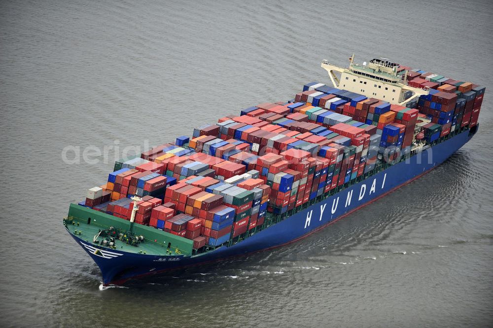 BRUNSBÜTTEL from above - Blick auf den von der koreanischen Reederei Hyundai Merchant Marine (HMM) gebauten Containerriese „ HYUNDAI Courage auf der Elbe. Der auf der koreanischen Werft Hyundai Heavy Industries gebaute Containerriese ist 339 m lang, 45,60 m breit und verfügt über eine Stellplatzkapazität von knapp 8566 TEU (20-Fuß-Standardcontainer). Der maximale Tiefgang der „Hyundai Courage beträgt 14,50 m. View of the Korean from the shipping company Hyundai Merchant Marine (HMM) built container giant HYUNDAI Courage on the Elbe.