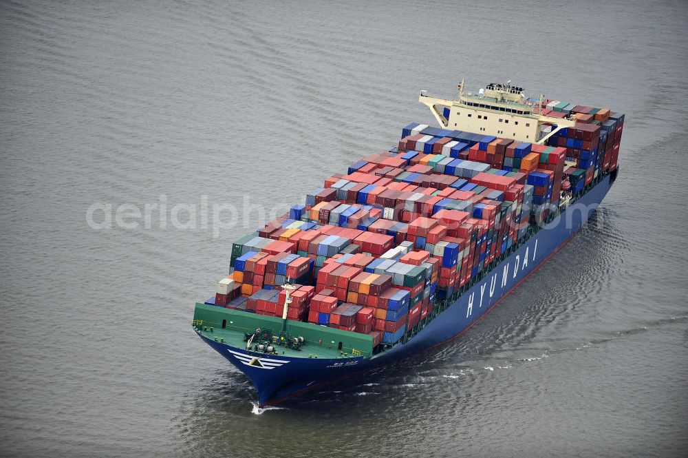 Aerial image BRUNSBÜTTEL - Blick auf den von der koreanischen Reederei Hyundai Merchant Marine (HMM) gebauten Containerriese „ HYUNDAI Courage auf der Elbe. Der auf der koreanischen Werft Hyundai Heavy Industries gebaute Containerriese ist 339 m lang, 45,60 m breit und verfügt über eine Stellplatzkapazität von knapp 8566 TEU (20-Fuß-Standardcontainer). Der maximale Tiefgang der „Hyundai Courage beträgt 14,50 m. View of the Korean from the shipping company Hyundai Merchant Marine (HMM) built container giant HYUNDAI Courage on the Elbe.