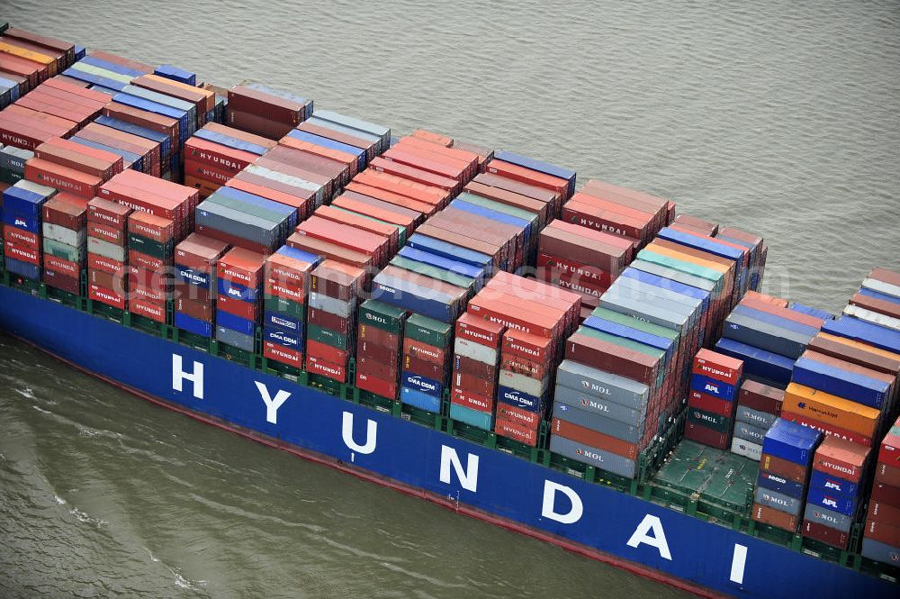 Aerial photograph BRUNSBÜTTEL - Blick auf den von der koreanischen Reederei Hyundai Merchant Marine (HMM) gebauten Containerriese „ HYUNDAI Courage auf der Elbe. Der auf der koreanischen Werft Hyundai Heavy Industries gebaute Containerriese ist 339 m lang, 45,60 m breit und verfügt über eine Stellplatzkapazität von knapp 8566 TEU (20-Fuß-Standardcontainer). Der maximale Tiefgang der „Hyundai Courage beträgt 14,50 m. View of the Korean from the shipping company Hyundai Merchant Marine (HMM) built container giant HYUNDAI Courage on the Elbe.