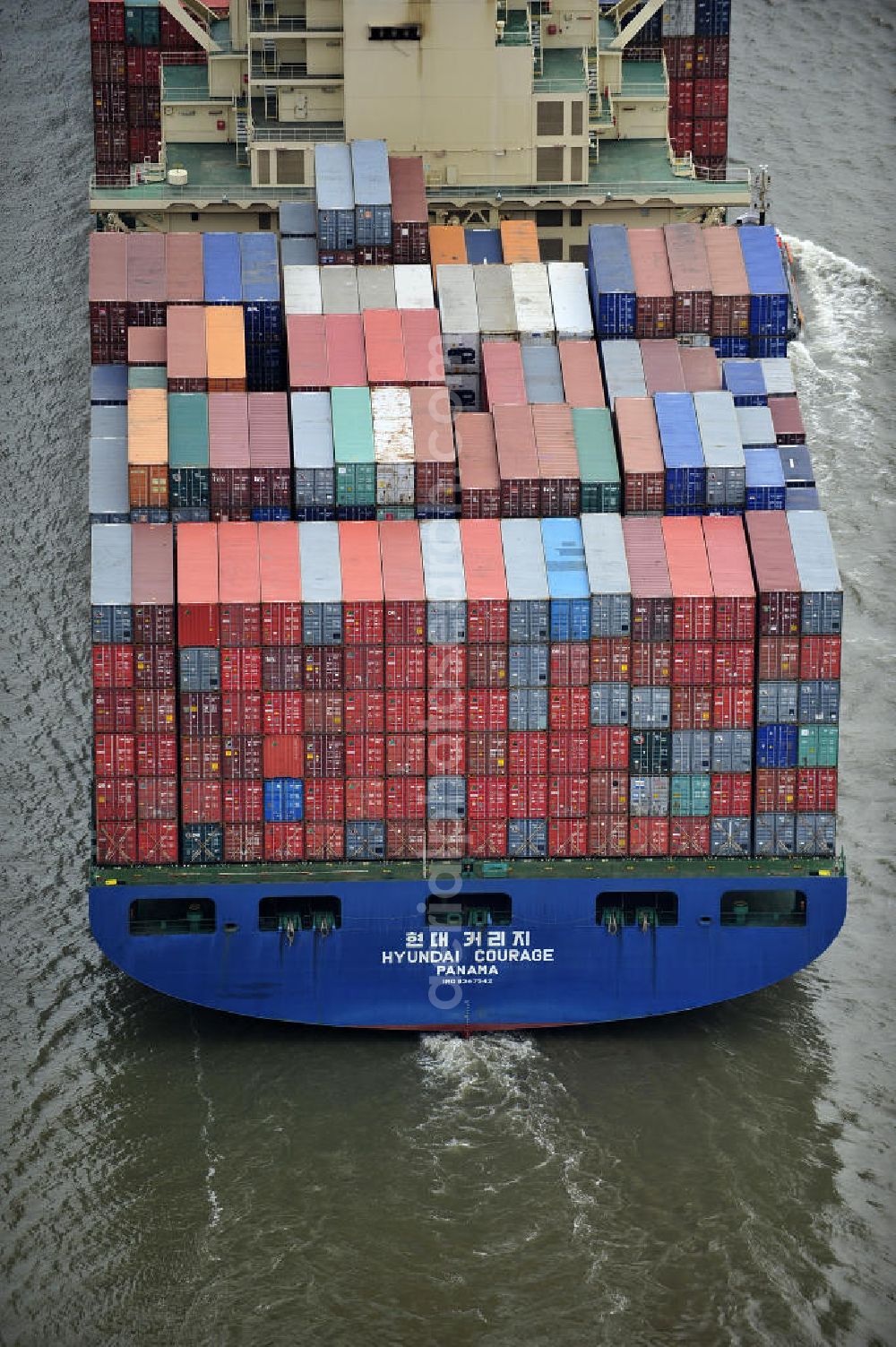 Aerial photograph BRUNSBÜTTEL - Blick auf den von der koreanischen Reederei Hyundai Merchant Marine (HMM) gebauten Containerriese „ HYUNDAI Courage auf der Elbe. Der auf der koreanischen Werft Hyundai Heavy Industries gebaute Containerriese ist 339 m lang, 45,60 m breit und verfügt über eine Stellplatzkapazität von knapp 8566 TEU (20-Fuß-Standardcontainer). Der maximale Tiefgang der „Hyundai Courage beträgt 14,50 m. View of the Korean from the shipping company Hyundai Merchant Marine (HMM) built container giant HYUNDAI Courage on the Elbe.