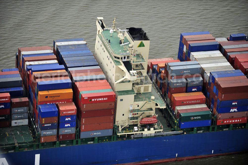 BRUNSBÜTTEL from above - Blick auf den von der koreanischen Reederei Hyundai Merchant Marine (HMM) gebauten Containerriese „ HYUNDAI Courage auf der Elbe. Der auf der koreanischen Werft Hyundai Heavy Industries gebaute Containerriese ist 339 m lang, 45,60 m breit und verfügt über eine Stellplatzkapazität von knapp 8566 TEU (20-Fuß-Standardcontainer). Der maximale Tiefgang der „Hyundai Courage beträgt 14,50 m. View of the Korean from the shipping company Hyundai Merchant Marine (HMM) built container giant HYUNDAI Courage on the Elbe.