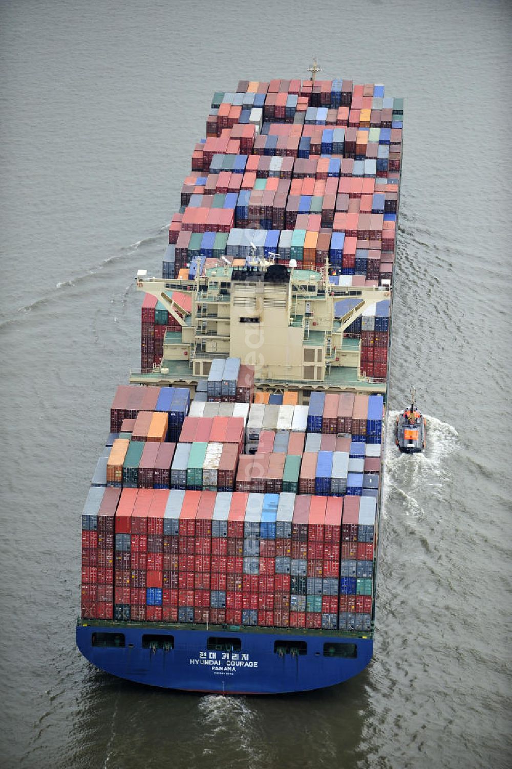 BRUNSBÜTTEL from the bird's eye view: Blick auf den von der koreanischen Reederei Hyundai Merchant Marine (HMM) gebauten Containerriese „ HYUNDAI Courage auf der Elbe. Der auf der koreanischen Werft Hyundai Heavy Industries gebaute Containerriese ist 339 m lang, 45,60 m breit und verfügt über eine Stellplatzkapazität von knapp 8566 TEU (20-Fuß-Standardcontainer). Der maximale Tiefgang der „Hyundai Courage beträgt 14,50 m. View of the Korean from the shipping company Hyundai Merchant Marine (HMM) built container giant HYUNDAI Courage on the Elbe.