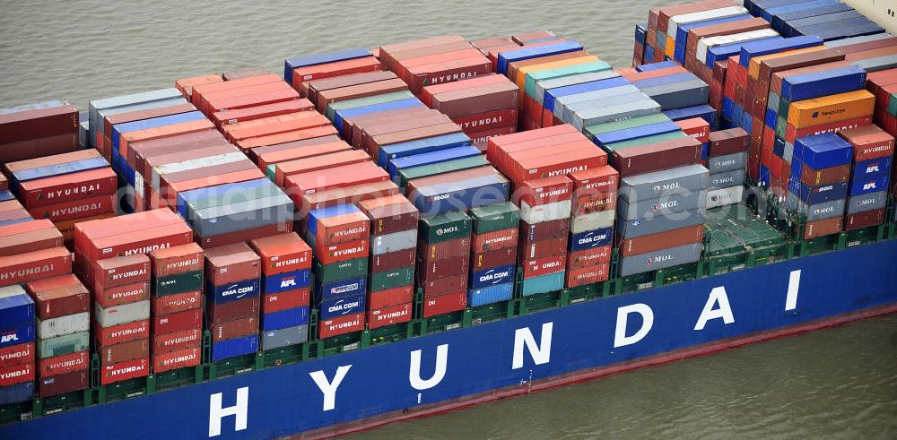 Aerial photograph BRUNSBÜTTEL - Blick auf den von der koreanischen Reederei Hyundai Merchant Marine (HMM) gebauten Containerriese „ HYUNDAI Courage auf der Elbe. Der auf der koreanischen Werft Hyundai Heavy Industries gebaute Containerriese ist 339 m lang, 45,60 m breit und verfügt über eine Stellplatzkapazität von knapp 8566 TEU (20-Fuß-Standardcontainer). Der maximale Tiefgang der „Hyundai Courage beträgt 14,50 m. View of the Korean from the shipping company Hyundai Merchant Marine (HMM) built container giant HYUNDAI Courage on the Elbe.