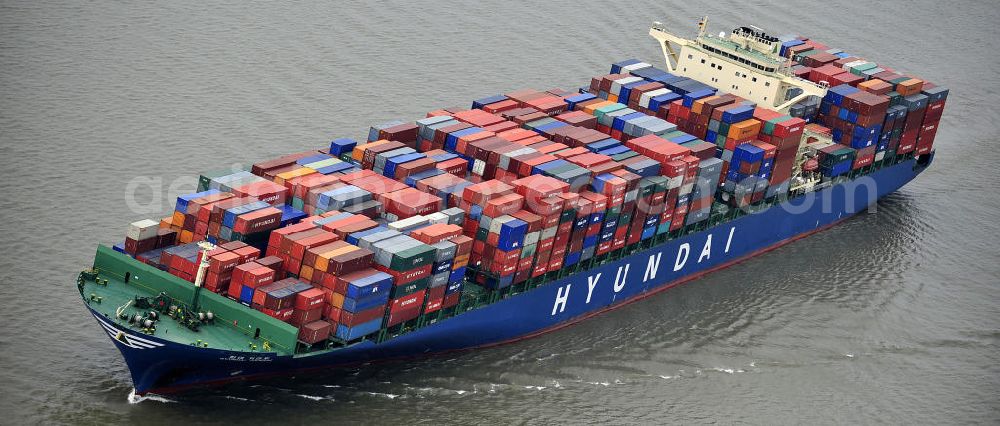 BRUNSBÜTTEL from above - Blick auf den von der koreanischen Reederei Hyundai Merchant Marine (HMM) gebauten Containerriese „ HYUNDAI Courage auf der Elbe. Der auf der koreanischen Werft Hyundai Heavy Industries gebaute Containerriese ist 339 m lang, 45,60 m breit und verfügt über eine Stellplatzkapazität von knapp 8566 TEU (20-Fuß-Standardcontainer). Der maximale Tiefgang der „Hyundai Courage beträgt 14,50 m. View of the Korean from the shipping company Hyundai Merchant Marine (HMM) built container giant HYUNDAI Courage on the Elbe.