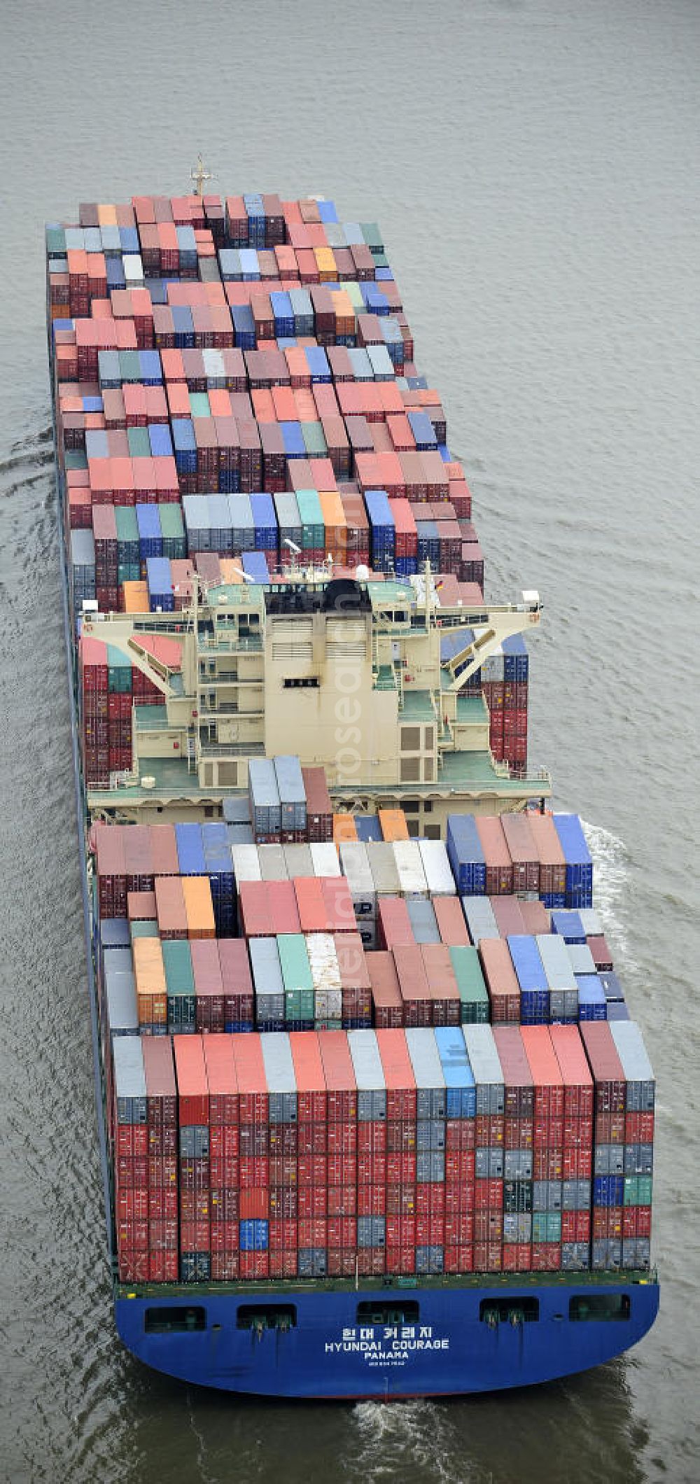 Aerial photograph BRUNSBÜTTEL - Blick auf den von der koreanischen Reederei Hyundai Merchant Marine (HMM) gebauten Containerriese „ HYUNDAI Courage auf der Elbe. Der auf der koreanischen Werft Hyundai Heavy Industries gebaute Containerriese ist 339 m lang, 45,60 m breit und verfügt über eine Stellplatzkapazität von knapp 8566 TEU (20-Fuß-Standardcontainer). Der maximale Tiefgang der „Hyundai Courage beträgt 14,50 m. View of the Korean from the shipping company Hyundai Merchant Marine (HMM) built container giant HYUNDAI Courage on the Elbe.