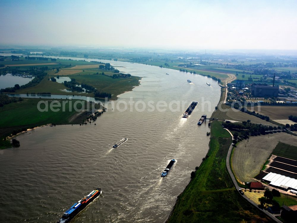 Aerial photograph Emmerich am Rhein - Container ships on the river Rhine in the city of Emmerich on Rhine in the state of North Rhine-Westphalia. The river marks the border to the Netherlands. Cargo shipping is especially important in the area, the metropolitan area also includes the Rhine port