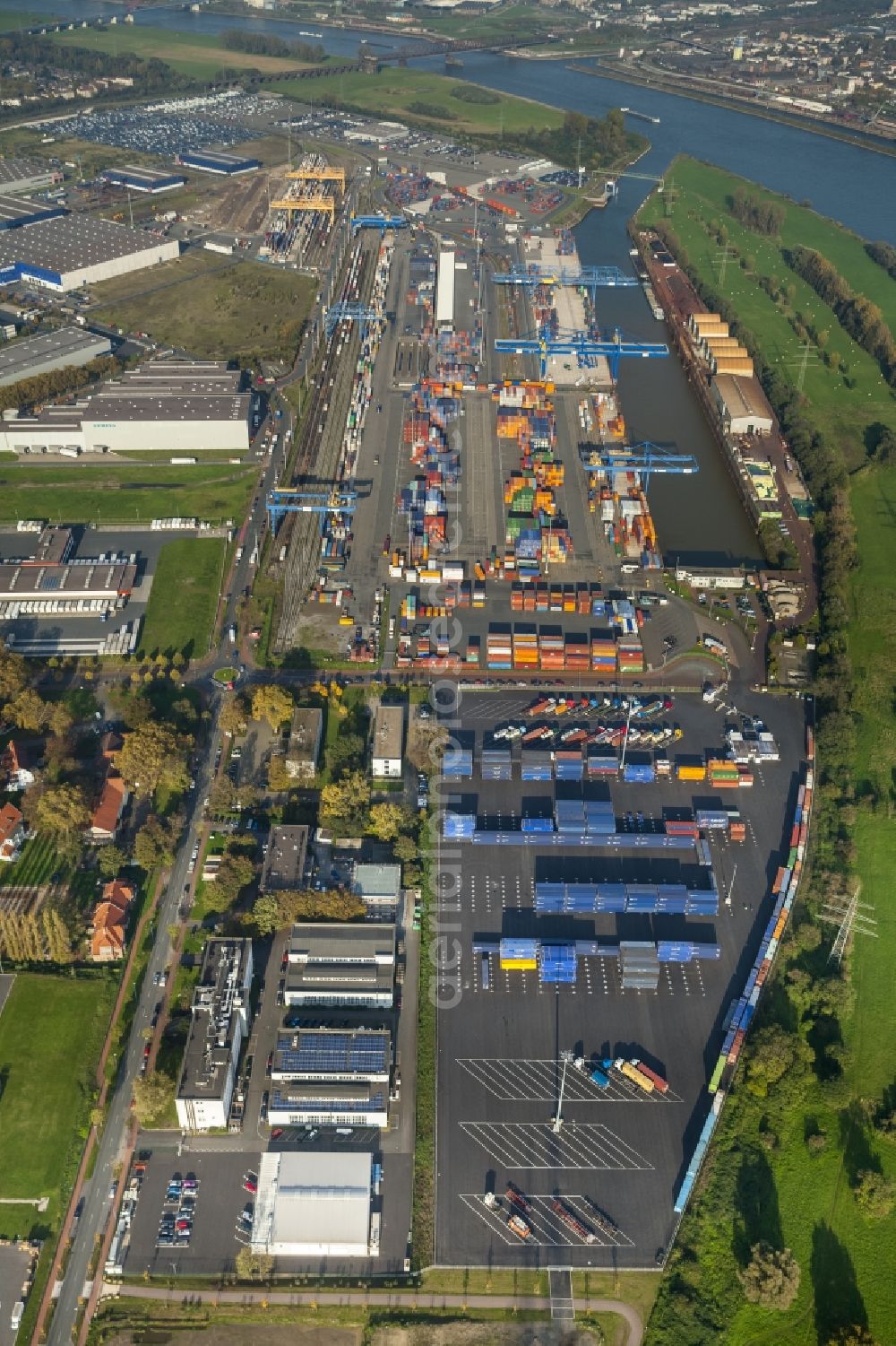 Duisburg from the bird's eye view: Container storage LOGPORT Logistic Center Duisburg GmbH. Container terminal of the DIT Duisburg Intermodal Terminal GmbH. Unloading and loading of cargo and shipping containers on the Rhine. The terminal is located in an industrial area in Duisburg Friemersheim district in the state of North Rhine-Westphalia