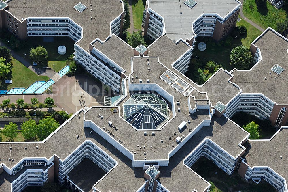 Aerial image Frankfurt am Main - Blick auf den Dachbereich und die Glas- Pyramide des Lurgihaus, einem Bürogebäudekomplex in Frankfurt-Heddernheim. Es entstand 1987 als erster Neubau des Mertonviertels auf dem ehemaligen Werksgelände der Vereinigten Deutschen Metallwerke und gehört zu den größten Bürogebäuden Deutschlands. Von einem viereckigen Zentralbau zweigen sieben stark gegliederte Nebengebäude ab. Ursprünglich diente der Komplex als Hauptquartier der Lurgi AG, um die im Frankfurter Stadtgebiet verteilten Standorte zusammenzufassen. Nach einer Verschlankung des Unternehmens wurden weitere Mieter in das Gebäude aufgenommen, unter an derem die Deutsche Finanzagentur. Heutiger Eigentümer ist der britische Fonds Puma Brandenburg Limited, der das Gebäude von der Deka Immobilien Investment GmbH erwarb. Das Gebäude ist an die MG Vermögensverwaltungs GmbH ( mgvv ) als Generalmieter vermietet. Roof and the glass pyramid of the Lurgi - House in Frankfurt - Heddernheim.