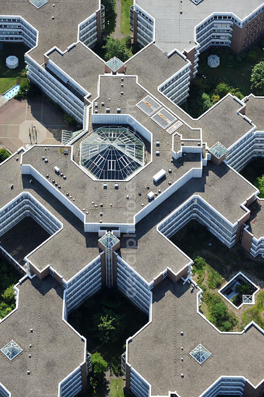 Frankfurt am Main from above - Blick auf den Dachbereich und die Glas- Pyramide des Lurgihaus, einem Bürogebäudekomplex in Frankfurt-Heddernheim. Es entstand 1987 als erster Neubau des Mertonviertels auf dem ehemaligen Werksgelände der Vereinigten Deutschen Metallwerke und gehört zu den größten Bürogebäuden Deutschlands. Von einem viereckigen Zentralbau zweigen sieben stark gegliederte Nebengebäude ab. Ursprünglich diente der Komplex als Hauptquartier der Lurgi AG, um die im Frankfurter Stadtgebiet verteilten Standorte zusammenzufassen. Nach einer Verschlankung des Unternehmens wurden weitere Mieter in das Gebäude aufgenommen, unter an derem die Deutsche Finanzagentur. Heutiger Eigentümer ist der britische Fonds Puma Brandenburg Limited, der das Gebäude von der Deka Immobilien Investment GmbH erwarb. Das Gebäude ist an die MG Vermögensverwaltungs GmbH ( mgvv ) als Generalmieter vermietet. Roof and the glass pyramid of the Lurgi - House in Frankfurt - Heddernheim.