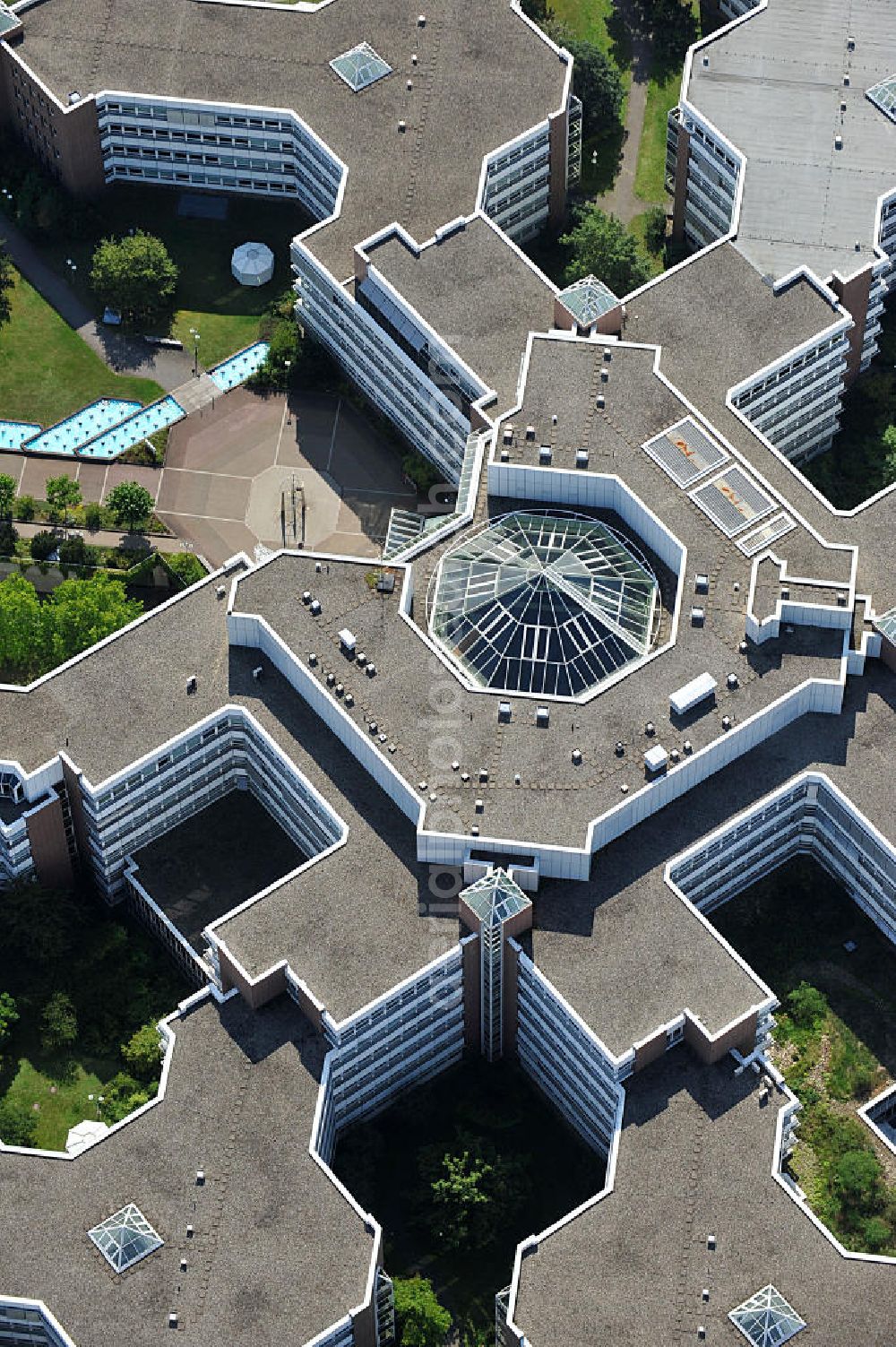 Frankfurt am Main from the bird's eye view: Blick auf den Dachbereich und die Glas- Pyramide des Lurgihaus, einem Bürogebäudekomplex in Frankfurt-Heddernheim. Es entstand 1987 als erster Neubau des Mertonviertels auf dem ehemaligen Werksgelände der Vereinigten Deutschen Metallwerke und gehört zu den größten Bürogebäuden Deutschlands. Von einem viereckigen Zentralbau zweigen sieben stark gegliederte Nebengebäude ab. Ursprünglich diente der Komplex als Hauptquartier der Lurgi AG, um die im Frankfurter Stadtgebiet verteilten Standorte zusammenzufassen. Nach einer Verschlankung des Unternehmens wurden weitere Mieter in das Gebäude aufgenommen, unter an derem die Deutsche Finanzagentur. Heutiger Eigentümer ist der britische Fonds Puma Brandenburg Limited, der das Gebäude von der Deka Immobilien Investment GmbH erwarb. Das Gebäude ist an die MG Vermögensverwaltungs GmbH ( mgvv ) als Generalmieter vermietet. Roof and the glass pyramid of the Lurgi - House in Frankfurt - Heddernheim.