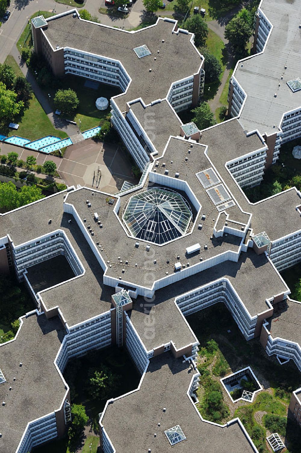 Aerial image Frankfurt am Main - Blick auf den Dachbereich und die Glas- Pyramide des Lurgihaus, einem Bürogebäudekomplex in Frankfurt-Heddernheim. Es entstand 1987 als erster Neubau des Mertonviertels auf dem ehemaligen Werksgelände der Vereinigten Deutschen Metallwerke und gehört zu den größten Bürogebäuden Deutschlands. Von einem viereckigen Zentralbau zweigen sieben stark gegliederte Nebengebäude ab. Ursprünglich diente der Komplex als Hauptquartier der Lurgi AG, um die im Frankfurter Stadtgebiet verteilten Standorte zusammenzufassen. Nach einer Verschlankung des Unternehmens wurden weitere Mieter in das Gebäude aufgenommen, unter an derem die Deutsche Finanzagentur. Heutiger Eigentümer ist der britische Fonds Puma Brandenburg Limited, der das Gebäude von der Deka Immobilien Investment GmbH erwarb. Das Gebäude ist an die MG Vermögensverwaltungs GmbH ( mgvv ) als Generalmieter vermietet. Roof and the glass pyramid of the Lurgi - House in Frankfurt - Heddernheim.