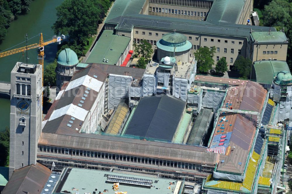 Aerial photograph München - Blick auf das Deutsche Museum auf der Museumsinsel an der Isar an der Ludwigsbrücke. Derzeit laufen umfangreiche Fassadensanierungsarbeiten und die Neueindeckung des kompletten Dachaufbaus mit einem Kupferdach. Das Deutsche Museum (offizieller Name: Deutsches Museum von Meisterwerken der Naturwissenschaft und Technik) in München ist das größte naturwissenschaftlich-technische Museum der Welt. Es werden rund 28.000 Objekte aus etwa 50 Bereichen der Naturwissenschaften und der Technik ausgestellt, die jährlich von etwa 1,5 Millionen Menschen besucht werden. Die Forschungseinrichtung ist Mitglied der Leibniz-Gemeinschaft. View the German Museum on Museum Island in the Isar River in Munich.