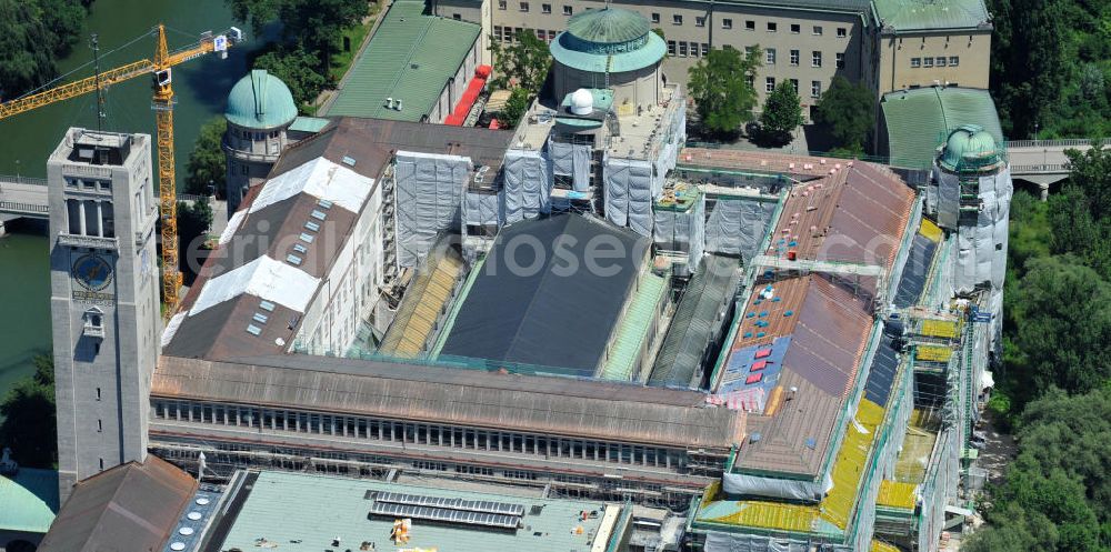 München from above - Blick auf das Deutsche Museum auf der Museumsinsel an der Isar an der Ludwigsbrücke. Derzeit laufen umfangreiche Fassadensanierungsarbeiten und die Neueindeckung des kompletten Dachaufbaus mit einem Kupferdach. Das Deutsche Museum (offizieller Name: Deutsches Museum von Meisterwerken der Naturwissenschaft und Technik) in München ist das größte naturwissenschaftlich-technische Museum der Welt. Es werden rund 28.000 Objekte aus etwa 50 Bereichen der Naturwissenschaften und der Technik ausgestellt, die jährlich von etwa 1,5 Millionen Menschen besucht werden. Die Forschungseinrichtung ist Mitglied der Leibniz-Gemeinschaft. View the German Museum on Museum Island in the Isar River in Munich.