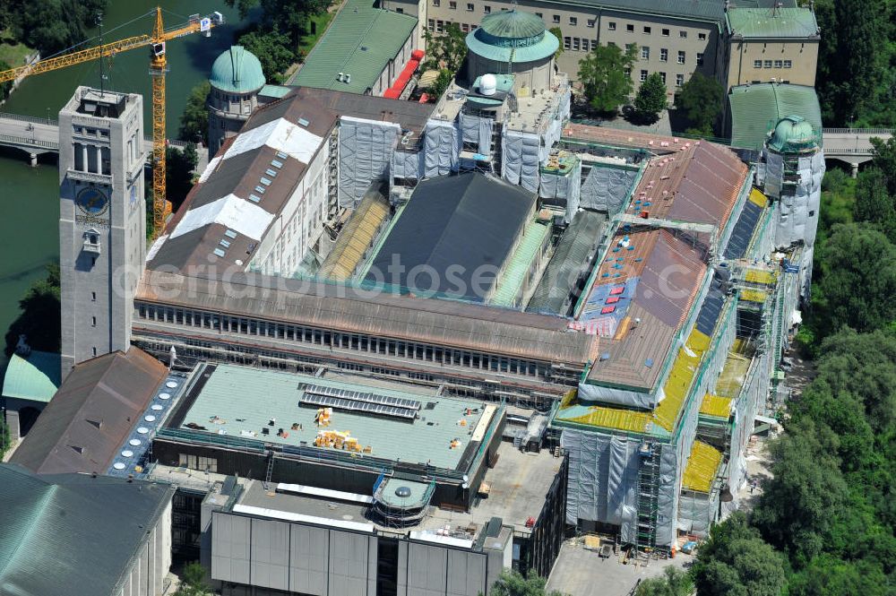 München from the bird's eye view: Blick auf das Deutsche Museum auf der Museumsinsel an der Isar an der Ludwigsbrücke. Derzeit laufen umfangreiche Fassadensanierungsarbeiten und die Neueindeckung des kompletten Dachaufbaus mit einem Kupferdach. Das Deutsche Museum (offizieller Name: Deutsches Museum von Meisterwerken der Naturwissenschaft und Technik) in München ist das größte naturwissenschaftlich-technische Museum der Welt. Es werden rund 28.000 Objekte aus etwa 50 Bereichen der Naturwissenschaften und der Technik ausgestellt, die jährlich von etwa 1,5 Millionen Menschen besucht werden. Die Forschungseinrichtung ist Mitglied der Leibniz-Gemeinschaft. View the German Museum on Museum Island in the Isar River in Munich.