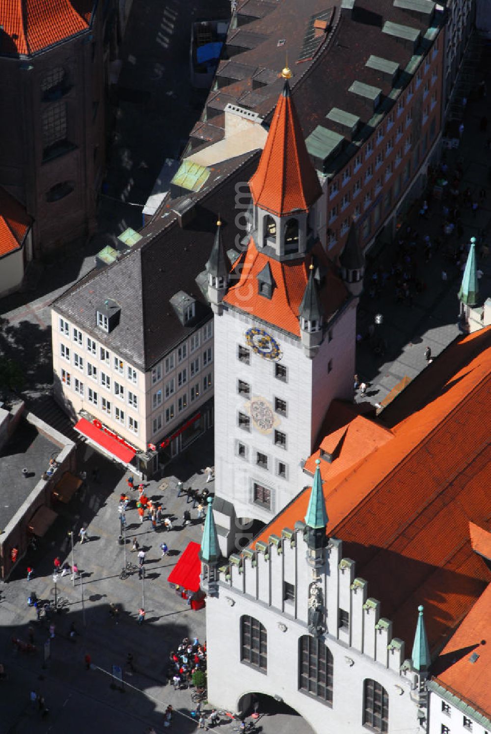 Aerial photograph München - Blick auf das Alte Rathaus am Marienplatz in München. Das Alte Rathaus, bis 1874 Sitz des Stadtrates, ist ein Repräsentationsgebäude der Stadtverwaltung in München am Marienplatz. Nachdem die Stadtverwaltung 1874 in den ersten Bauabschnitt des Neuen Rathauses umgezogen ist und das nun mehr Altes Rathaus genannte Gebäude vor allem zu repräsentativen Anlässen genutzt wurde, wurde im Erdgeschoss eine Durchfahrt zum Tal mit einer separaten Fußgängerpassage durchgebrochen. 1934/35 wurde die heutige Durchfahrt in gotisierenden Formen über das ganze Erdgeschoss hin ausgedehnt. Wie viele Bauten in München, wurde das Alte Rathaus im Zweiten Weltkrieg komplett zerstört und erst ab 1952 wiederaufgebaut. Noch einmal 18 Jahre später beschloss der Stadtrat auch den Turm wiederaufzubauen, der nun 56 m hoch über den Marienplatz hinausragt. Das Spielzeugmuseum, das sich im Turm des Alten Rathaus befindet, lässt Kinderträume wieder lebendig werden. Die Sammlung der Familie Ivan Steiger am Marienplatz ist eine der größten Kollektionen alter europäischer und amerikanischer Spielsachen: mit Puppen und Puppenstuben, Eisenbahnen, Flugzeugen, Plüschbären, Karussels, Zoo mit Tieren etc. Über die vier Stockwerke des Turms breiten sich liebenswerte Schätze aus der Vor-Game-boy-Ära aus. Die Ausstellung, die Jung und Alt beeindruckt, zeigt auch das neueste Sammlerobjekt: Barbie und die Ausstellung Teddybär 100 Jahre alt. Kontakt: Spielzeugmuseum, Marienplatz 15 (Im Alten Rathausturm), 80331 München, Tel.: 089/29 40 01