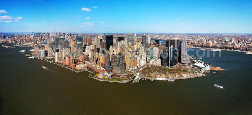 Aerial photograph New York - View of the island and the district of Manhattan in New York from the harbor side. The skyscrapers and ferry terminals are located in the Financial District of the borough