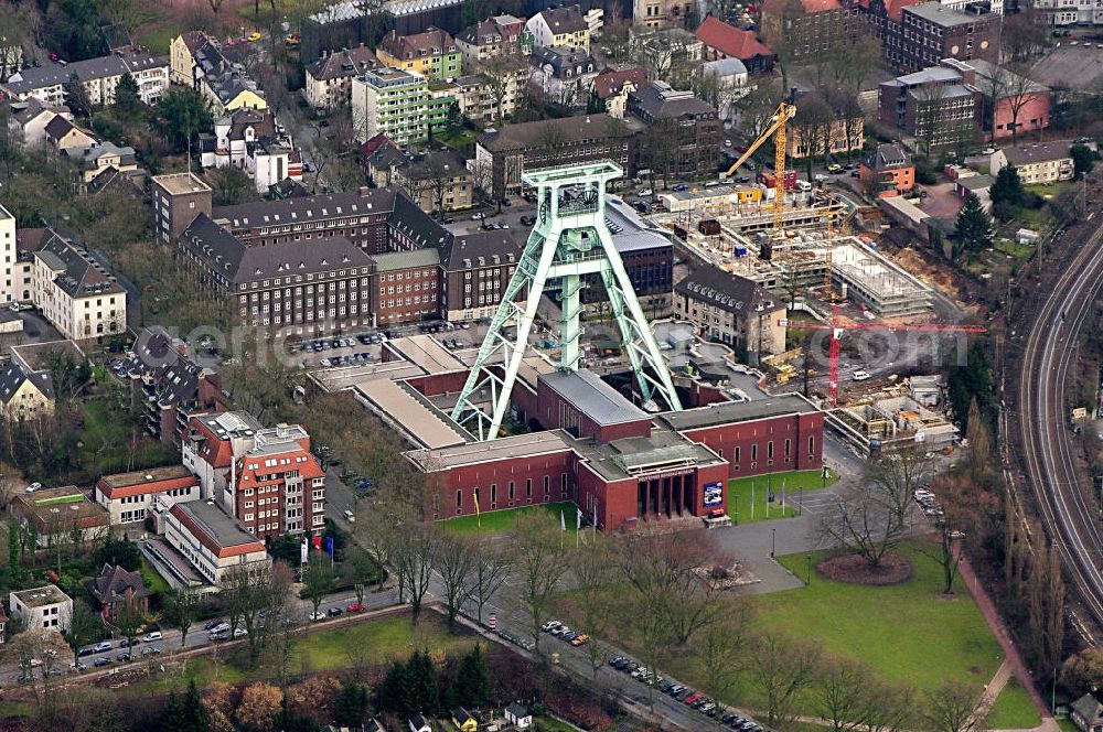 BOCHUM from above - Das Deutsche Bergbau-Museum Bochum (DBM) ist mit seinen rund 400.000 Besuchern pro Jahr eines der meist besuchten Museen Deutschlands. Es ist eines der bedeutendsten Bergbaumuseen der Welt und zugleich ein renommiertes Forschungsinstitut für Montangeschichte.Übertägige Ausstellungen und ein originalgetreues Anschauungsbergwerk unterhalb des Museumsgeländes eröffnen den Besuchern Einblicke in die Welt des Bergbaus. Forschungsschwerpunkte der Wissenschaftler sind die „Geschichte und Technik des Montanwesens“ sowie „Dokumentation und Schutz von Kulturgut“. Das Museum ist als Forschungseinrichtung Mitglied der Leibniz-Gemeinschaft.Die Anfänge des Bergbau-Museums gehen zurück auf die 1860er Jahre, als die Westfälische Berggewerkschaftskasse (WBK) eine ständige Ausstellung „Bergbaulicher Utensilien“ in Bochum einrichtet, die hauptsächlich dem Bergschulunterricht diente. Ende der 1920er Jahre wurden von Vertretern der WBK und der Stadt Bochum Überlegungen zur Gründung eines öffentlich zugänglichen „Bergbau-Museums“ entwickelt.