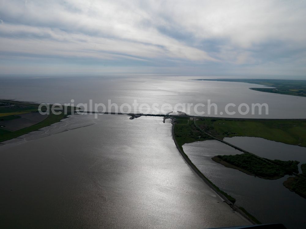 Tönning from above - The Eider flood barrier in Tönning in the state of Schleswig-Holstein. The barrage is located on the mouth of the river Eider, going into the North Sea. The barrier is in place for protection against storm flooding of the North Sea. It was built in 1967, consisting of 2 rows with 5 gates each to provide double flooding protection