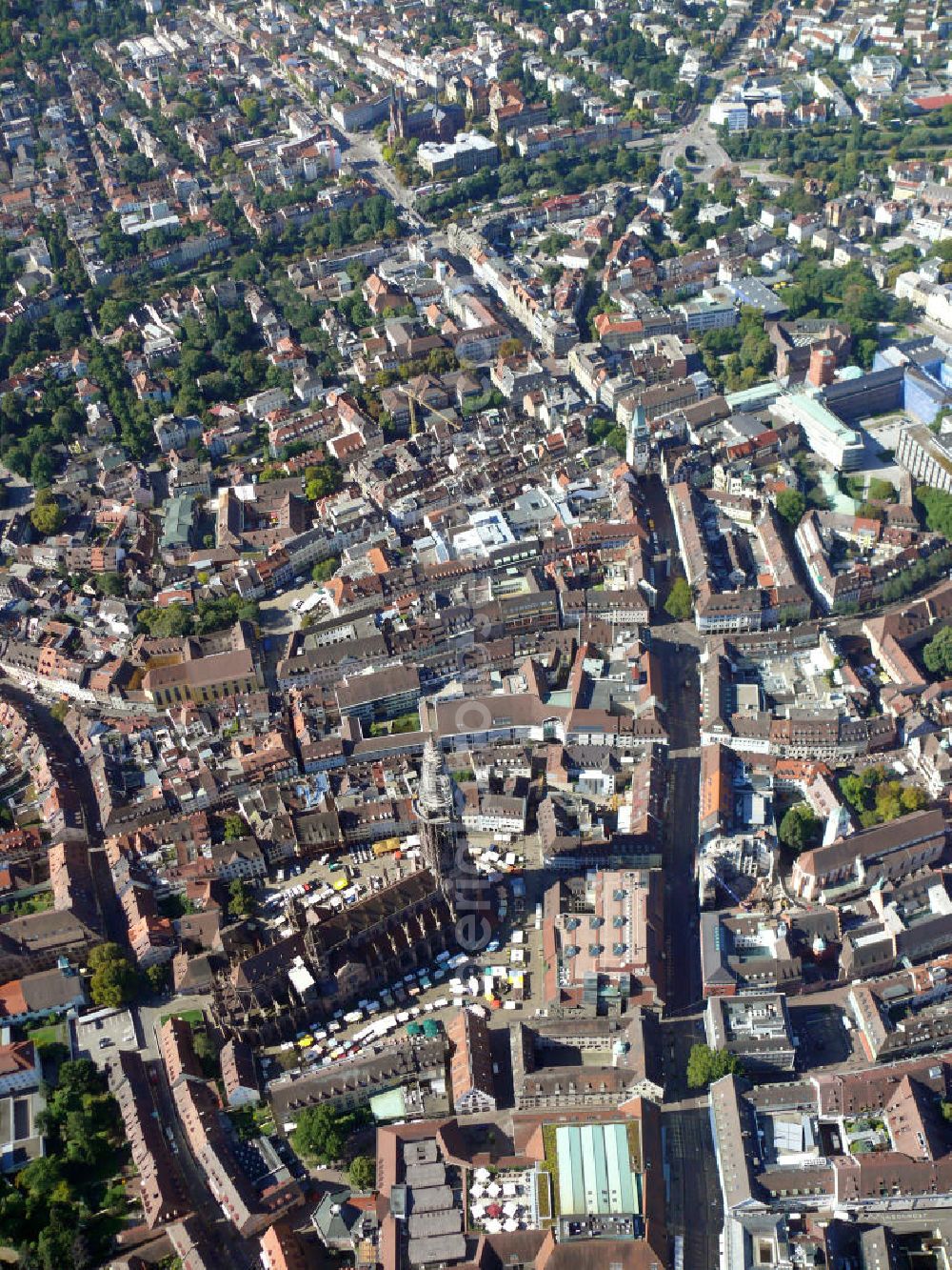 Aerial image Freiburg im Breisgau - Das Freiburger Münster, auch Münster Unserer Lieben Frau genannt, ist eine römisch-katholisch geprägte Stadtkirche im Ortsteil Altstadt in Freiburg, Baden-Württemberg. Die Kathedrale ist weltweit sehr bekannt, u.a. durch den berühmten 116 m hohen Turm. Die Kirche gilt als Meisterwerk der Gotik. The Freiburger Münster, also called Muenster Unserer Lieben Frau, is a roman catholic municipal church in the district Altstadt of Freiburg, Baden-Wuerttemberg. The cathedral is world-famous, among other things for the 116-meter-high tower. The church is considered a gothic style masterpiece.