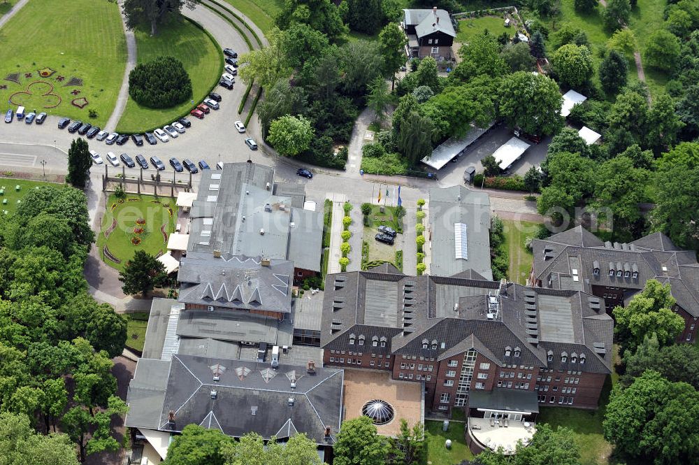 Magdeburg from above - Blick auf das Herrenkrug Parkhotel an der Elbe. Die erstmalige Erwähnung des Herrenkrugs war im 17. Jahrhundert, als Wirtshaus. Die Umliegende Parkanlage entwickelte sich im 19. Jahrhundert zum Ausflugsziel und das Restaurant wurde zu einem der größten in Deutschland. Der Park wird 1995 unter Denkmalschutz gestellt. Das heutige Hotel entstand in den 1990er Jahren und wurde mit dem Architekturpreis ausgezeichnet. Das 4 Sterne Hotel liegt direkt am Ufer der Elbe. Es bietet einen Wellness- und Spa Bereich, sowie Seminar- und Konferenzräume. Kontakt: Herrenkrug GmbH, Herrenkrug Parkhotel an der Elbe, Herrenkrug 3, 39114 Magdeburg, Tel. 0391 / 85 08 0, info@herrenkrug.de