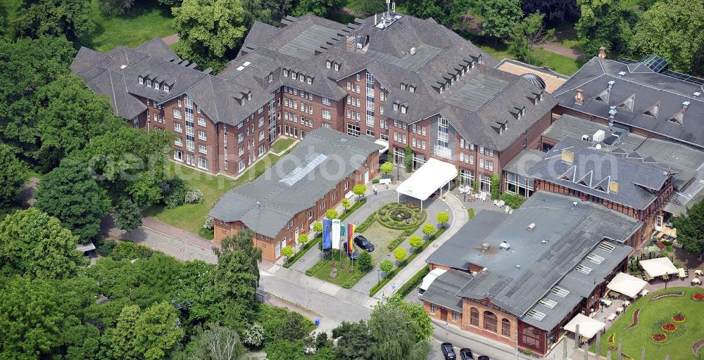 Magdeburg from above - Blick auf das Herrenkrug Parkhotel an der Elbe. Die erstmalige Erwähnung des Herrenkrugs war im 17. Jahrhundert, als Wirtshaus. Die Umliegende Parkanlage entwickelte sich im 19. Jahrhundert zum Ausflugsziel und das Restaurant wurde zu einem der größten in Deutschland. Der Park wird 1995 unter Denkmalschutz gestellt. Das heutige Hotel entstand in den 1990er Jahren und wurde mit dem Architekturpreis ausgezeichnet. Das 4 Sterne Hotel liegt direkt am Ufer der Elbe. Es bietet einen Wellness- und Spa Bereich, sowie Seminar- und Konferenzräume. Kontakt: Herrenkrug GmbH, Herrenkrug Parkhotel an der Elbe, Herrenkrug 3, 39114 Magdeburg, Tel. 0391 / 85 08 0, info@herrenkrug.de