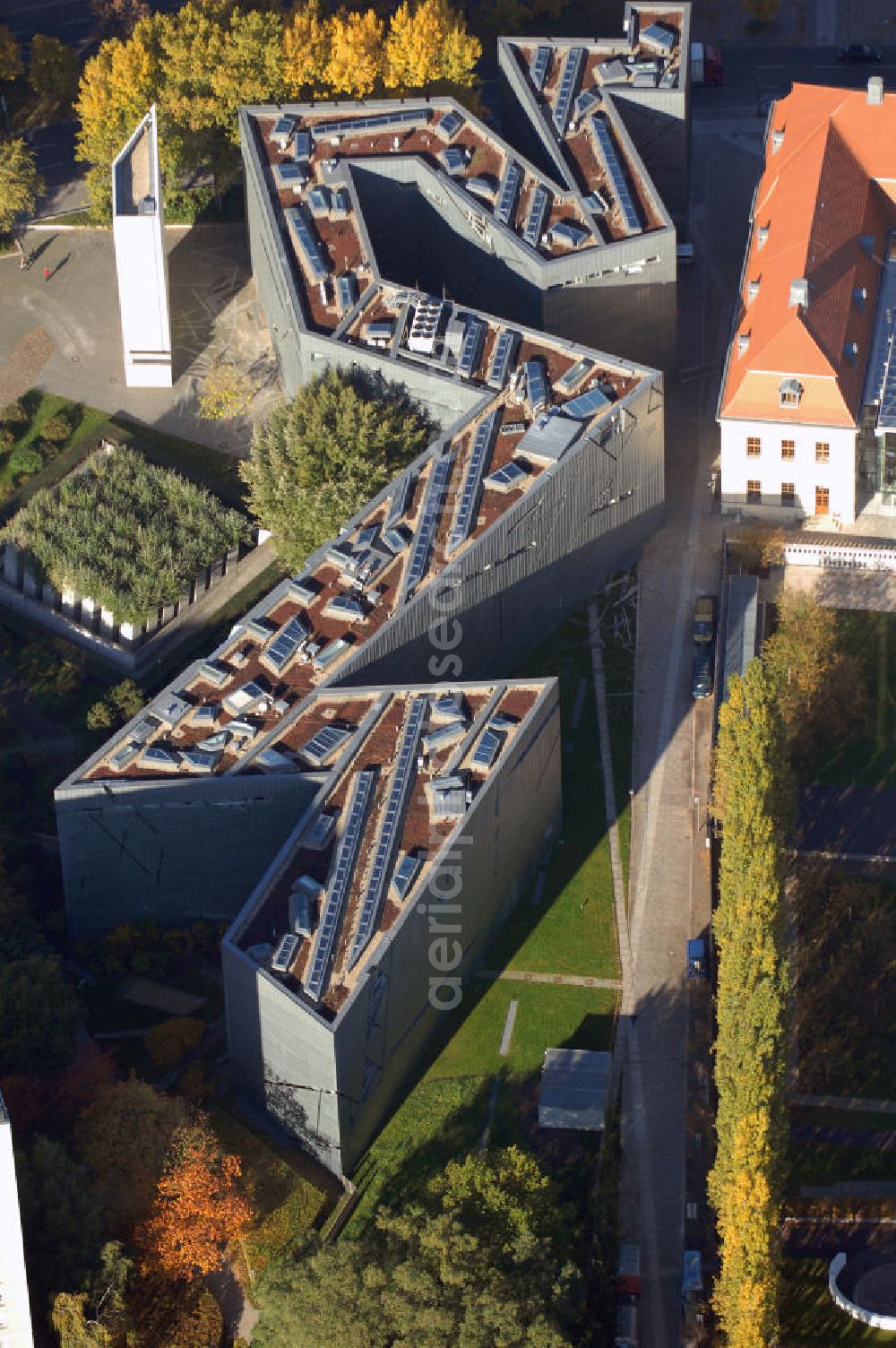 Aerial photograph Berlin - Das Jüdische Museum Berlin zeigt dem Besucher zwei Jahrtausende deutsch-jüdische Geschichte, die Höhe- und Tiefpunkte der Beziehungen zwischen Juden und Nichtjuden in Deutschland. Das Museum beherbergt eine Dauerausstellung, mehrere Wechselausstellungen, ein umfassendes Archiv, das Rafael Roth Learning Center und Forschungseinrichtungen. All diese Abteilungen dienen dazu, jüdische Kultur und jüdisch-deutsche Geschichte darzustellen.Das Museumsgebäude in der Kreuzberger Lindenstraße verbindet den barocken Altbau des Collegienhauses (ehemaliger Sitz des Kammergerichts) mit einem Neubau. Der zickzackförmige Bau geht auf einen Entwurf des amerikanischen Architekten Daniel Libeskind zurück. Die im Freien fortgesetzte Form erinnert auch an einen geborstenen Davidstern.Das Museum ist eine Stiftung öffentlichen Rechts in der Verantwortung des Bundes unter der Direktion von W. Michael Blumenthal. Es hatte 2005 rund 690.000 Besucher und gehört damit zu den meistbesuchten Museen Berlins.