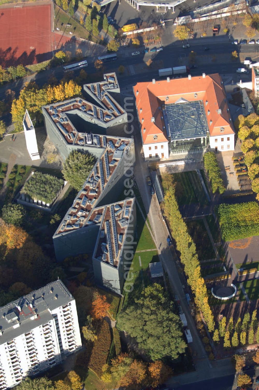 Berlin from the bird's eye view: Das Jüdische Museum Berlin zeigt dem Besucher zwei Jahrtausende deutsch-jüdische Geschichte, die Höhe- und Tiefpunkte der Beziehungen zwischen Juden und Nichtjuden in Deutschland. Das Museum beherbergt eine Dauerausstellung, mehrere Wechselausstellungen, ein umfassendes Archiv, das Rafael Roth Learning Center und Forschungseinrichtungen. All diese Abteilungen dienen dazu, jüdische Kultur und jüdisch-deutsche Geschichte darzustellen.Das Museumsgebäude in der Kreuzberger Lindenstraße verbindet den barocken Altbau des Collegienhauses (ehemaliger Sitz des Kammergerichts) mit einem Neubau. Der zickzackförmige Bau geht auf einen Entwurf des amerikanischen Architekten Daniel Libeskind zurück. Die im Freien fortgesetzte Form erinnert auch an einen geborstenen Davidstern.Das Museum ist eine Stiftung öffentlichen Rechts in der Verantwortung des Bundes unter der Direktion von W. Michael Blumenthal. Es hatte 2005 rund 690.000 Besucher und gehört damit zu den meistbesuchten Museen Berlins.