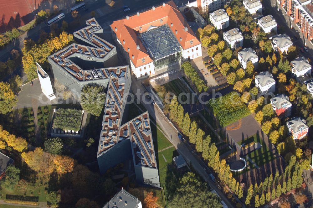 Aerial image Berlin - Das Jüdische Museum Berlin zeigt dem Besucher zwei Jahrtausende deutsch-jüdische Geschichte, die Höhe- und Tiefpunkte der Beziehungen zwischen Juden und Nichtjuden in Deutschland. Das Museum beherbergt eine Dauerausstellung, mehrere Wechselausstellungen, ein umfassendes Archiv, das Rafael Roth Learning Center und Forschungseinrichtungen. All diese Abteilungen dienen dazu, jüdische Kultur und jüdisch-deutsche Geschichte darzustellen.Das Museumsgebäude in der Kreuzberger Lindenstraße verbindet den barocken Altbau des Collegienhauses (ehemaliger Sitz des Kammergerichts) mit einem Neubau. Der zickzackförmige Bau geht auf einen Entwurf des amerikanischen Architekten Daniel Libeskind zurück. Die im Freien fortgesetzte Form erinnert auch an einen geborstenen Davidstern.Das Museum ist eine Stiftung öffentlichen Rechts in der Verantwortung des Bundes unter der Direktion von W. Michael Blumenthal. Es hatte 2005 rund 690.000 Besucher und gehört damit zu den meistbesuchten Museen Berlins.