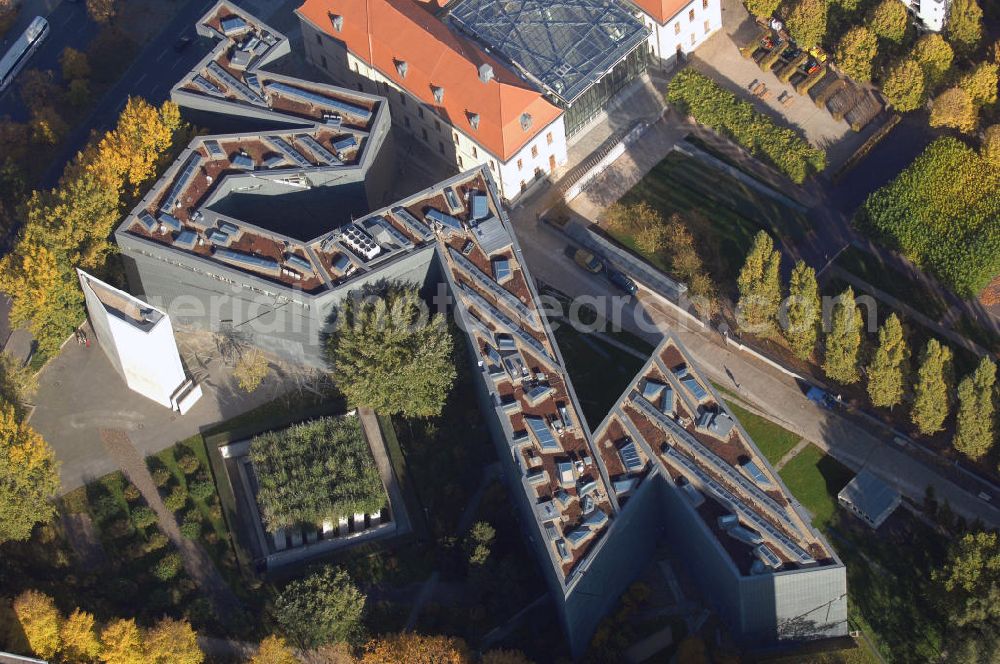 Berlin from above - Das Jüdische Museum Berlin zeigt dem Besucher zwei Jahrtausende deutsch-jüdische Geschichte, die Höhe- und Tiefpunkte der Beziehungen zwischen Juden und Nichtjuden in Deutschland. Das Museum beherbergt eine Dauerausstellung, mehrere Wechselausstellungen, ein umfassendes Archiv, das Rafael Roth Learning Center und Forschungseinrichtungen. All diese Abteilungen dienen dazu, jüdische Kultur und jüdisch-deutsche Geschichte darzustellen.Das Museumsgebäude in der Kreuzberger Lindenstraße verbindet den barocken Altbau des Collegienhauses (ehemaliger Sitz des Kammergerichts) mit einem Neubau. Der zickzackförmige Bau geht auf einen Entwurf des amerikanischen Architekten Daniel Libeskind zurück. Die im Freien fortgesetzte Form erinnert auch an einen geborstenen Davidstern.Das Museum ist eine Stiftung öffentlichen Rechts in der Verantwortung des Bundes unter der Direktion von W. Michael Blumenthal. Es hatte 2005 rund 690.000 Besucher und gehört damit zu den meistbesuchten Museen Berlins.