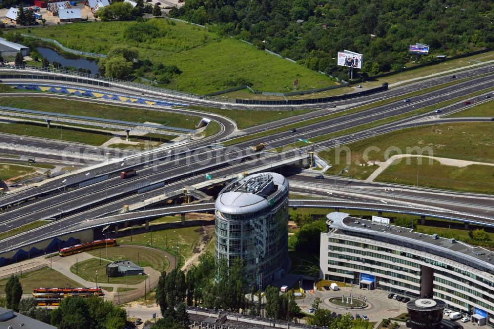 Warschau from above - The junction of the Expressway S79 in the Sluzewiec part of the district of Mokotow in Warsaw in Poland. The Droga ekspresowa S79 is a spur route running from North to the South towards the southern Warsaw motorway ring. The part adjacent to the Sasanki Street was completed in 2013. This part connects the Chopin Airport to the Expressway and Motorway network. The distinct round building is an office building of the BNP Paribas Bank in the office quarters of Trinity Park II