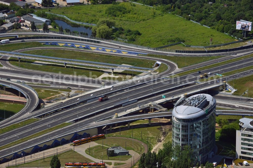 Warschau from the bird's eye view: The junction of the Expressway S79 in the Sluzewiec part of the district of Mokotow in Warsaw in Poland. The Droga ekspresowa S79 is a spur route running from North to the South towards the southern Warsaw motorway ring. The part adjacent to the Sasanki Street was completed in 2013. This part connects the Chopin Airport to the Expressway and Motorway network. The distinct round building is an office building of the BNP Paribas Bank in the office quarters of Trinity Park II