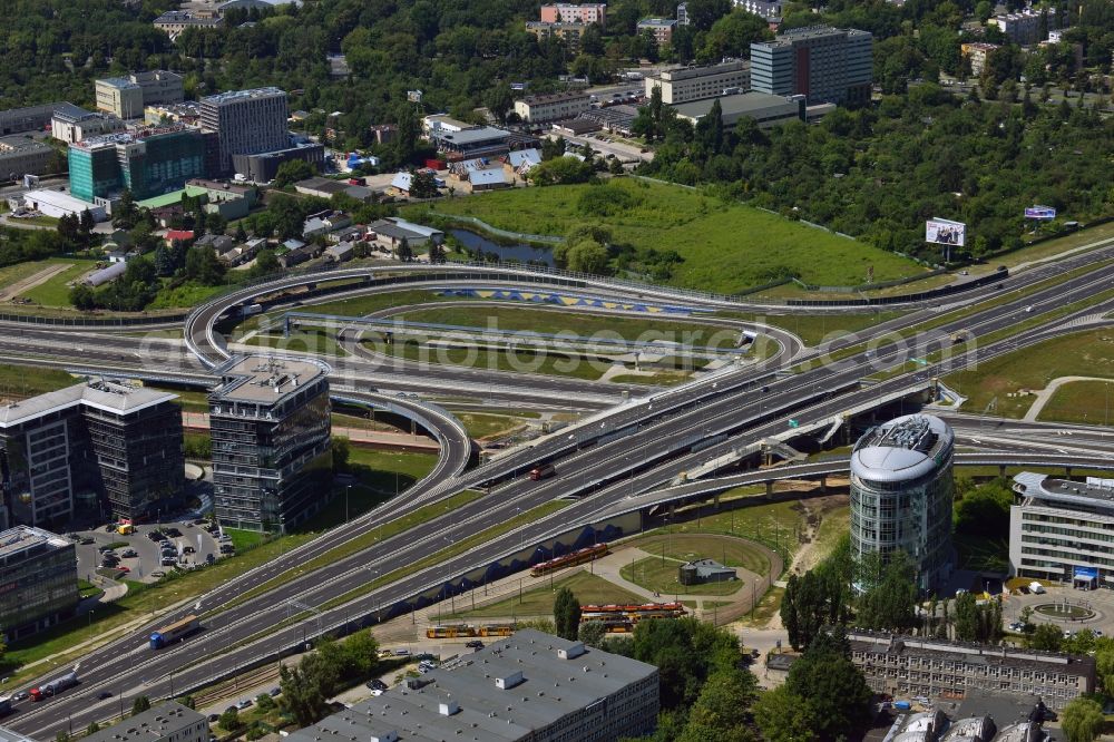 Aerial photograph Warschau - The junction of the Expressway S79 in the Sluzewiec part of the district of Mokotow in Warsaw in Poland. The Droga ekspresowa S79 is a spur route running from North to the South towards the southern Warsaw motorway ring. The part adjacent to the Sasanki Street was completed in 2013. This part connects the Chopin Airport to the Expressway and Motorway network. The distinct round building is an office building of the BNP Paribas Bank in the office quarters of Trinity Park II