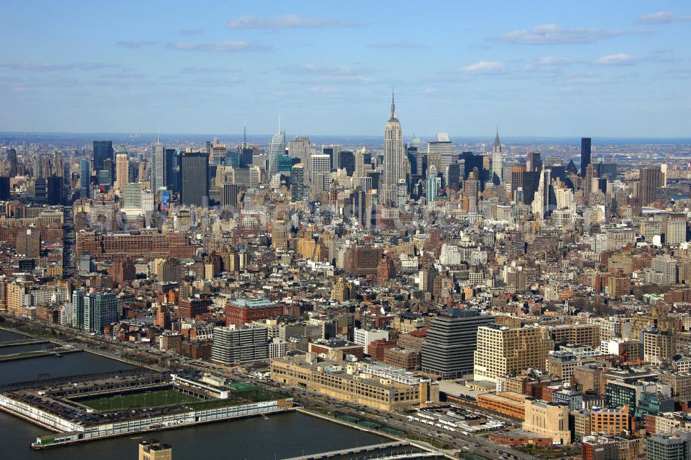 Aerial photograph New York - View of the shore of New York's Midtown West shore in the district of Manhattan with the boroughs of Chelsea and the skyline of Garment in the background. On the shore are the piers of the Hudson River park with sports field of Pier 40