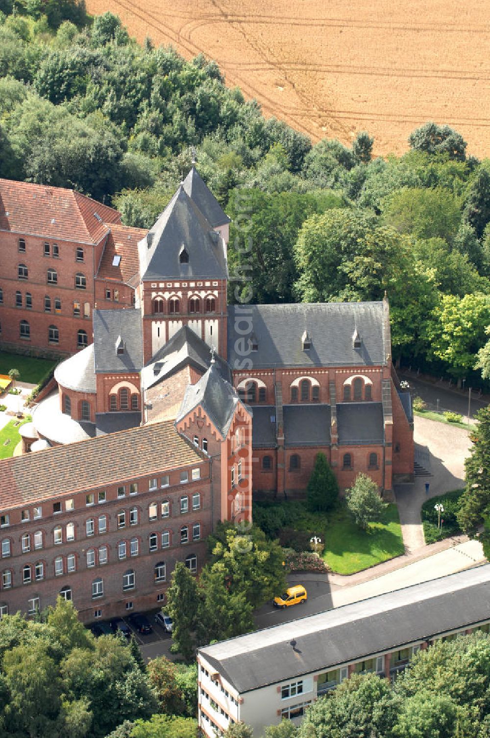 Aerial photograph Sankt Wendel - Blick auf das Missionshaus, das auch die Gottesburg an der Saar genannt wird. Inspiriert wurde dieser Name durch die burgenartige Architektur des romantischen Backsteinbaus. Erbaut wurde das Kloster um 1899, 1910 kam die imposante Klosterkirche, die das Herzstück der Anlage bildet, hinzu. Das dem Kloster angegliederte Gymnasium eröffnete 1899 mit 10 Schülern. Neben der Missionstätigkeit betreibt der Orden heute immer noch das Gymnasium, sowie Jugendarbeit, es ist ein Seniorenheim angegliedert und die Räumlichkeiten werden als Tagungsstätte angeboten. In der Kirche finden regelmäßig Konzerte statt, außerdem gibt es eine Buchhandlung und ein Museum. Kontakt: Missionshaus St. Wendel, Missionshausstr. 50, 66606 St. Wendel, Tel. 06851/ 805 0, st.wendelsteyler.de,