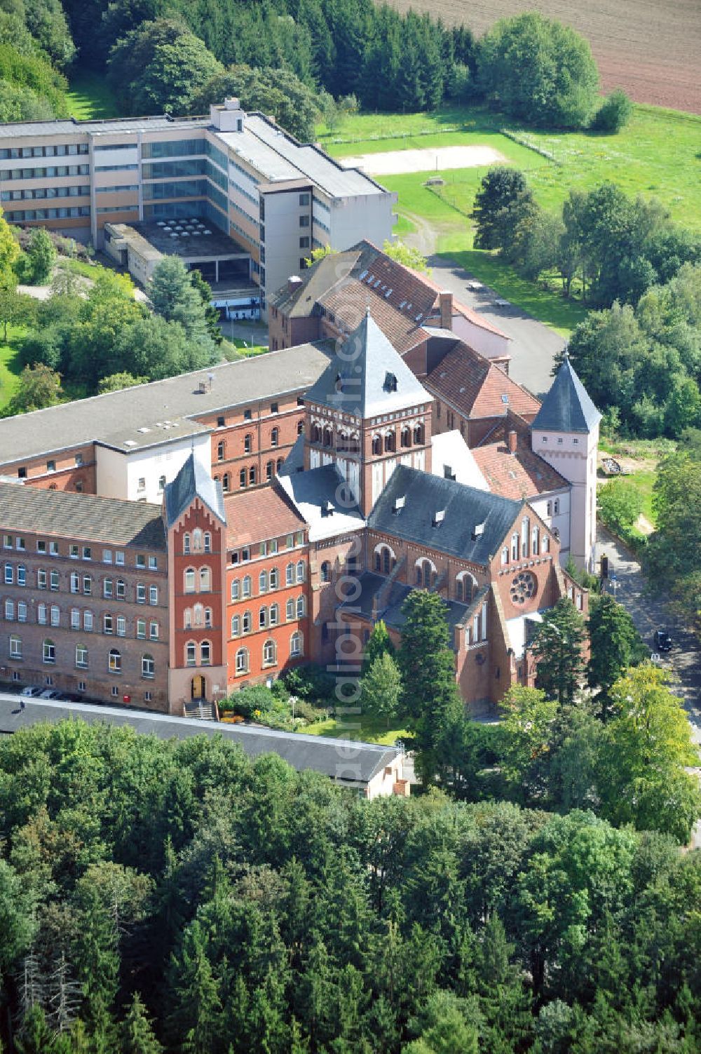 Sankt Wendel from the bird's eye view: Blick auf das Missionshaus, das auch die Gottesburg an der Saar genannt wird. Inspiriert wurde dieser Name durch die burgenartige Architektur des romantischen Backsteinbaus. Erbaut wurde das Kloster um 1899, 1910 kam die imposante Klosterkirche, die das Herzstück der Anlage bildet, hinzu. Das dem Kloster angegliederte Gymnasium eröffnete 1899 mit 10 Schülern. Neben der Missionstätigkeit betreibt der Orden heute immer noch das Gymnasium, sowie Jugendarbeit, es ist ein Seniorenheim angegliedert und die Räumlichkeiten werden als Tagungsstätte angeboten. In der Kirche finden regelmäßig Konzerte statt, außerdem gibt es eine Buchhandlung und ein Museum. The mission house in St. Wendel.