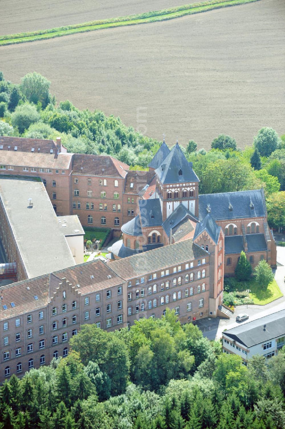 Sankt Wendel from the bird's eye view: Blick auf das Missionshaus, das auch die Gottesburg an der Saar genannt wird. Inspiriert wurde dieser Name durch die burgenartige Architektur des romantischen Backsteinbaus. Erbaut wurde das Kloster um 1899, 1910 kam die imposante Klosterkirche, die das Herzstück der Anlage bildet, hinzu. Das dem Kloster angegliederte Gymnasium eröffnete 1899 mit 10 Schülern. Neben der Missionstätigkeit betreibt der Orden heute immer noch das Gymnasium, sowie Jugendarbeit, es ist ein Seniorenheim angegliedert und die Räumlichkeiten werden als Tagungsstätte angeboten. In der Kirche finden regelmäßig Konzerte statt, außerdem gibt es eine Buchhandlung und ein Museum. The mission house in St. Wendel.