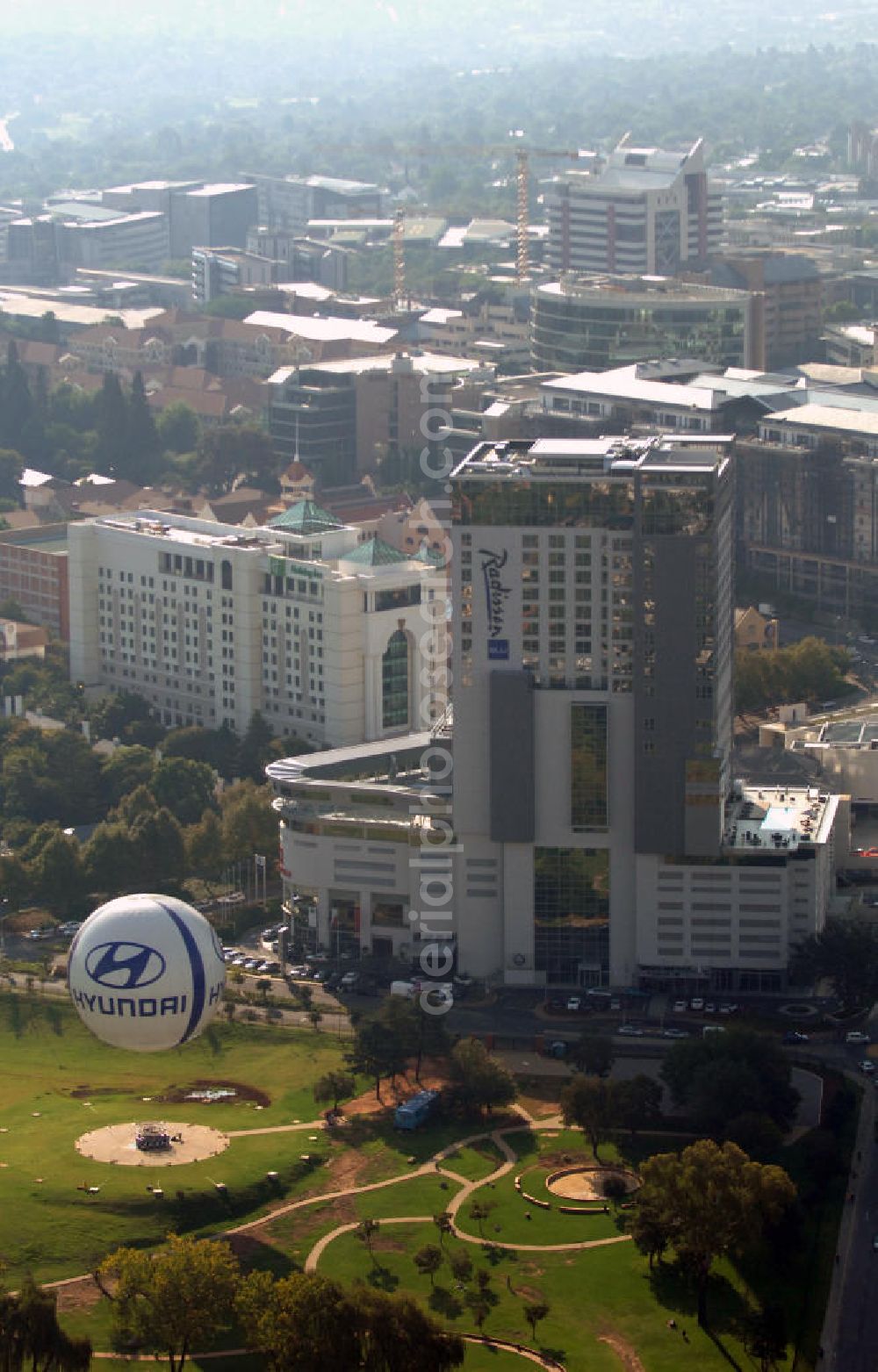 JOHANNESBURG from above - Blick auf das Radisson Blu Hotel und das dahinterliegende Holiday Inn in Johannesburg, Südafrika. Radisson Blu ist eine Hotelkette mit Hotels im Vier- bis Fünf-Sterne-Bereich und wird von der Rezidor Hotel Group geleitet. Die Hotelkette Holiday Inn gehört zur InterContinental Hotels Group plc.