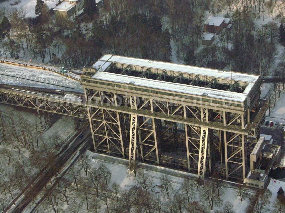 Aerial photograph Niederfinow / BRB - Der anhaltende Dauerfrost macht vor allem dem Personal des Schiffshebewerkes Niederfinow ordentlich zu schaffen. Im Bereich der Trogbrücke muß eine stündlich von Hand erneuerte Wasserrinne freigehalten werden, um mechanische Beschädigungen bei vollständiger Eisbildung auszuschließen. Das Schiffshebewerk ist bis heute ein wichtiger Teil der Wasserstrasse von der Havel bis zur Oder und seine Kapazität stößt an Grenzen. Natürlich wird bei hoher Beanstpruchung auch das Material müde, und somit kam es zuerst in den 80er Jahren zu einer Generalüberhohlung der Zugseile, Seilscheiben, Dichtungen und Antriebsmotoren. Allerdings ist es erstaunlich, daß keine nennenswerten Defekte von der Errichtung bis heute aufgetreten sind. Es ist eben ein Qualitätszeugnis der damaligen Industrie und des Handwerks. Das Schiffshebewerk Niederfinow stößt natürlich bereits seit langer Zeit an seine Kapazität. Aus diesem Grund steht bereits seit einigen Jahren ein neues Schiffshebewerk in Planung. In den nächsten 2Jahren soll voraussichtlich der Baubeginn sein. Es entsteht zwischen dem alten Schiffshebewerk und der alten Schleusentreppe.