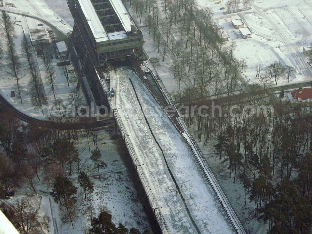 Niederfinow / BRB from the bird's eye view: Der anhaltende Dauerfrost macht vor allem dem Personal des Schiffshebewerkes Niederfinow ordentlich zu schaffen. Im Bereich der Trogbrücke muß eine stündlich von Hand erneuerte Wasserrinne freigehalten werden, um mechanische Beschädigungen bei vollständiger Eisbildung auszuschließen. Das Schiffshebewerk ist bis heute ein wichtiger Teil der Wasserstrasse von der Havel bis zur Oder und seine Kapazität stößt an Grenzen. Natürlich wird bei hoher Beanstpruchung auch das Material müde, und somit kam es zuerst in den 80er Jahren zu einer Generalüberhohlung der Zugseile, Seilscheiben, Dichtungen und Antriebsmotoren. Allerdings ist es erstaunlich, daß keine nennenswerten Defekte von der Errichtung bis heute aufgetreten sind. Es ist eben ein Qualitätszeugnis der damaligen Industrie und des Handwerks. Das Schiffshebewerk Niederfinow stößt natürlich bereits seit langer Zeit an seine Kapazität. Aus diesem Grund steht bereits seit einigen Jahren ein neues Schiffshebewerk in Planung. In den nächsten 2Jahren soll voraussichtlich der Baubeginn sein. Es entsteht zwischen dem alten Schiffshebewerk und der alten Schleusentreppe.