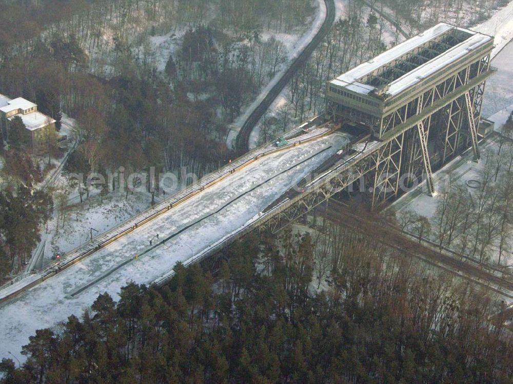 Niederfinow / BRB from above - Der anhaltende Dauerfrost macht vor allem dem Personal des Schiffshebewerkes Niederfinow ordentlich zu schaffen. Im Bereich der Trogbrücke muß eine stündlich von Hand erneuerte Wasserrinne freigehalten werden, um mechanische Beschädigungen bei vollständiger Eisbildung auszuschließen. Das Schiffshebewerk ist bis heute ein wichtiger Teil der Wasserstrasse von der Havel bis zur Oder und seine Kapazität stößt an Grenzen. Natürlich wird bei hoher Beanstpruchung auch das Material müde, und somit kam es zuerst in den 80er Jahren zu einer Generalüberhohlung der Zugseile, Seilscheiben, Dichtungen und Antriebsmotoren. Allerdings ist es erstaunlich, daß keine nennenswerten Defekte von der Errichtung bis heute aufgetreten sind. Es ist eben ein Qualitätszeugnis der damaligen Industrie und des Handwerks. Das Schiffshebewerk Niederfinow stößt natürlich bereits seit langer Zeit an seine Kapazität. Aus diesem Grund steht bereits seit einigen Jahren ein neues Schiffshebewerk in Planung. In den nächsten 2Jahren soll voraussichtlich der Baubeginn sein. Es entsteht zwischen dem alten Schiffshebewerk und der alten Schleusentreppe.