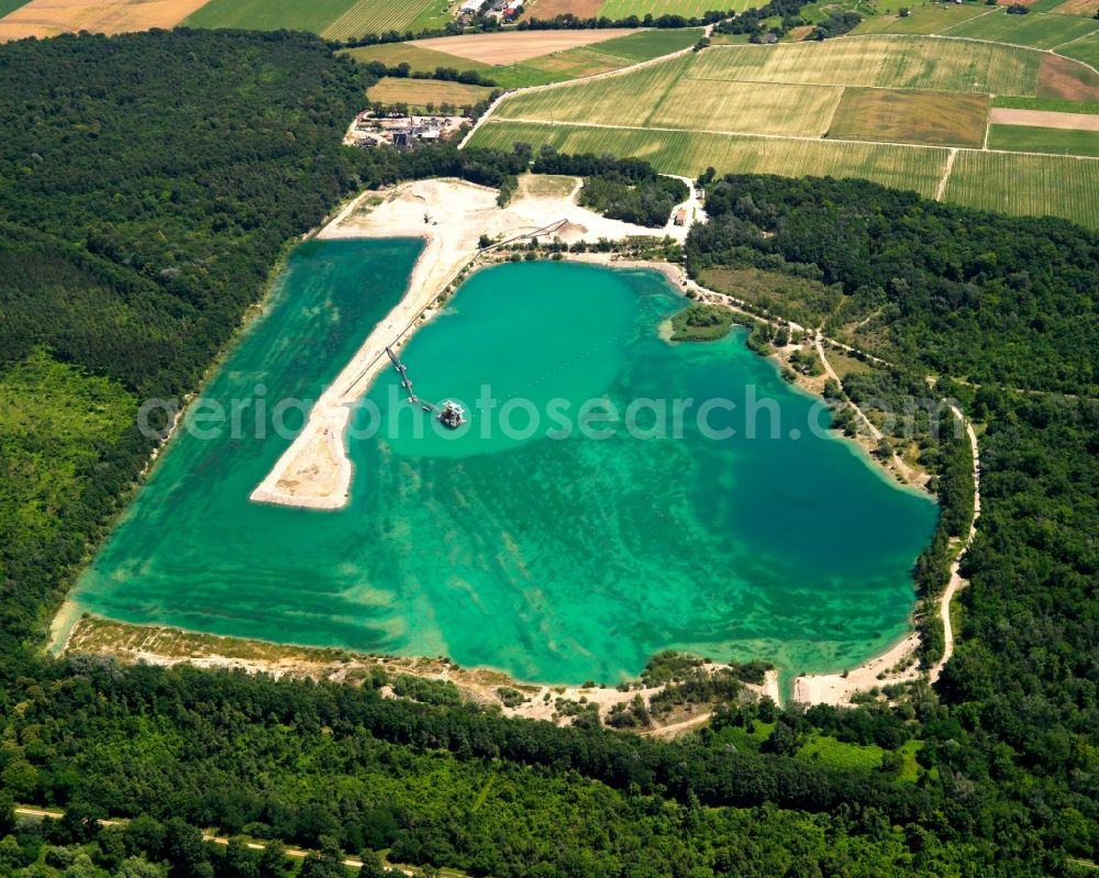 Hartheim am Rhein from above - The quarry pond in Hartheim on Rhine in the state of Baden-Württemberg. Originally created for mining, the lake is today publicly open as an excavated swimming lake with a distinct land hook