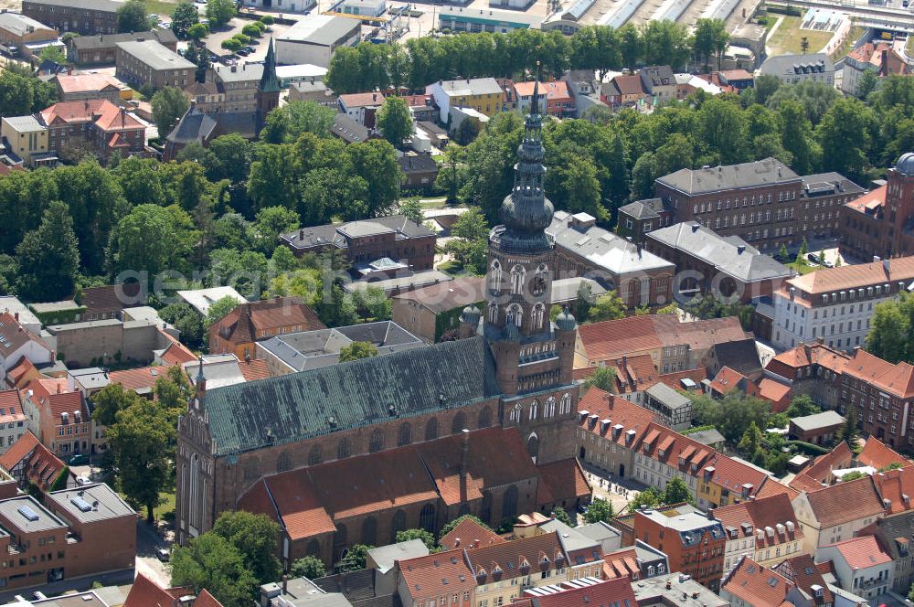 Aerial image Greifswald - Blick auf den Dom St. Nikolai. Der gotische Backsteinbau ist das Wahrzeichen der Stadt und wird im Volksmund Langer Nikolaus genannt. Der Dom stammt aus dem 13. Jahrhundert. Der Turm ist ca. 100 m hoch und begehbar, das Dach besteht aus Kupfer und hat die Form einer verdoppelten Zwiebelkuppel. Kontakt: Evangelische Kirchengemeinde St. Nikolai, Domstraße 54, 17489 Greifswald, Tel. 03834 / 2627, st.nikolai@kirchenkreis-greifswald.de