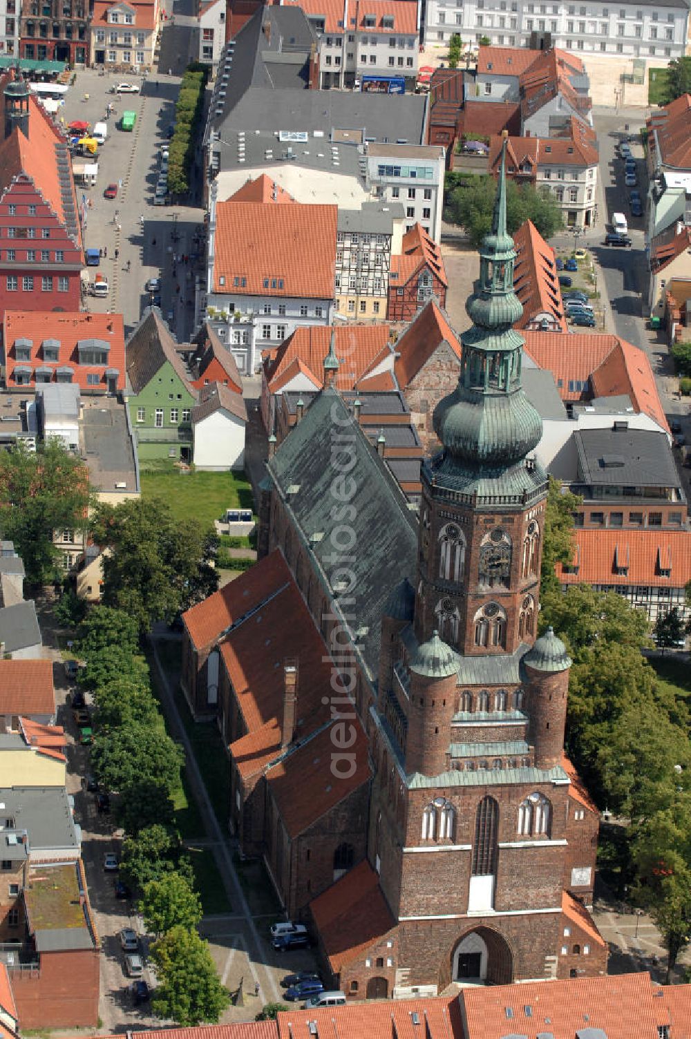 Aerial photograph Greifswald - Blick auf den Dom St. Nikolai. Der gotische Backsteinbau ist das Wahrzeichen der Stadt und wird im Volksmund Langer Nikolaus genannt. Der Dom stammt aus dem 13. Jahrhundert. Der Turm ist ca. 100 m hoch und begehbar, das Dach besteht aus Kupfer und hat die Form einer verdoppelten Zwiebelkuppel. Kontakt: Evangelische Kirchengemeinde St. Nikolai, Domstraße 54, 17489 Greifswald, Tel. 03834 / 2627, st.nikolai@kirchenkreis-greifswald.de