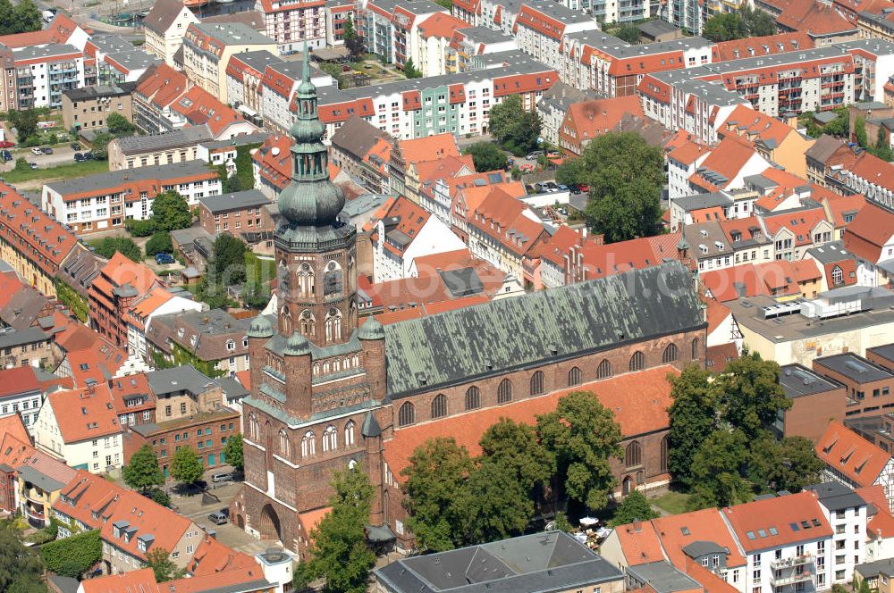 Aerial photograph Greifswald - Blick auf den Dom St. Nikolai. Der gotische Backsteinbau ist das Wahrzeichen der Stadt und wird im Volksmund Langer Nikolaus genannt. Der Dom stammt aus dem 13. Jahrhundert. Der Turm ist ca. 100 m hoch und begehbar, das Dach besteht aus Kupfer und hat die Form einer verdoppelten Zwiebelkuppel. Kontakt: Evangelische Kirchengemeinde St. Nikolai, Domstraße 54, 17489 Greifswald, Tel. 03834 / 2627, st.nikolai@kirchenkreis-greifswald.de