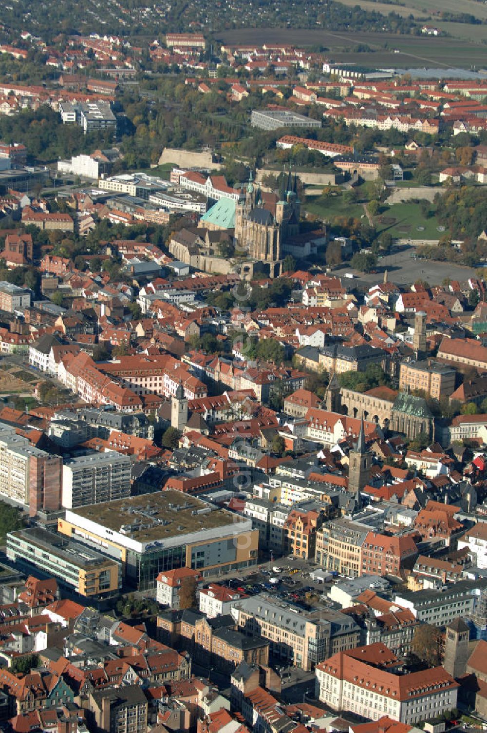 Aerial photograph Erfurt - Blick auf den Domberg mit dem in Europa einzigartigen Kirchenensenble des Domes St. Marien und der Kirche St. Severi. Beide Kiechen beruhen auf Vorgängerbauten. Der Dom St. Marien entstandt im 8. Jahrhundert als Bischofkirche, die verschiedenen Bauphasen im Stil der Romanik und der Gotik sind im Bauwerk deutlich zu erkennen. Die St. Severikirche wurde im 9. Jahrhundert gegründet, der eigentliche Bau ist jedoch älter und beherbergte ein benediktinisches Nonnenkloster. Von dem ursprünglich romanischem Bauwerk ist nichts mehr zu erkennen und die Pfarrkirche weißt nach dem Neubau um 1350 nun einen klaren Spätgotischen Stil auf. Die beiden Kirchen sind Wahrzeichen der Stadt. Kontakt: Kath. Kirchengemeinde St. Marien, Kath. Kirchengemeinde St. Severi, Severihof 2, 99084 Erfurt, Tel. 0361 / 5 76 96-0,