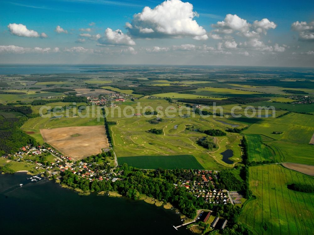 Aerial photograph Untergöhren - The golfing facilities and the golf club in the borough of Göhren-Lebbin on lake Fleesensee in the state of Mecklenburg-Vorpommern. The borough is a renowned climatic spa with a local golf club consisting of 5 different courses and over 70 holes. There is also a round golf arena for training. The landscape is informed by the region of the Mecklenburg lake district. The village in the foreground on the shore of the lake is Untergöhren