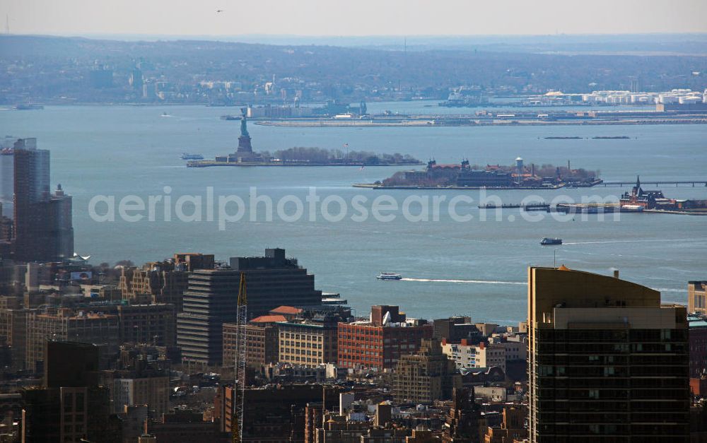 New York from the bird's eye view: View of the harbor of New York with the Statue of Liberty on Liberty Island and Ellis Island in front of the bank of Jersey City in the state of New Jersey