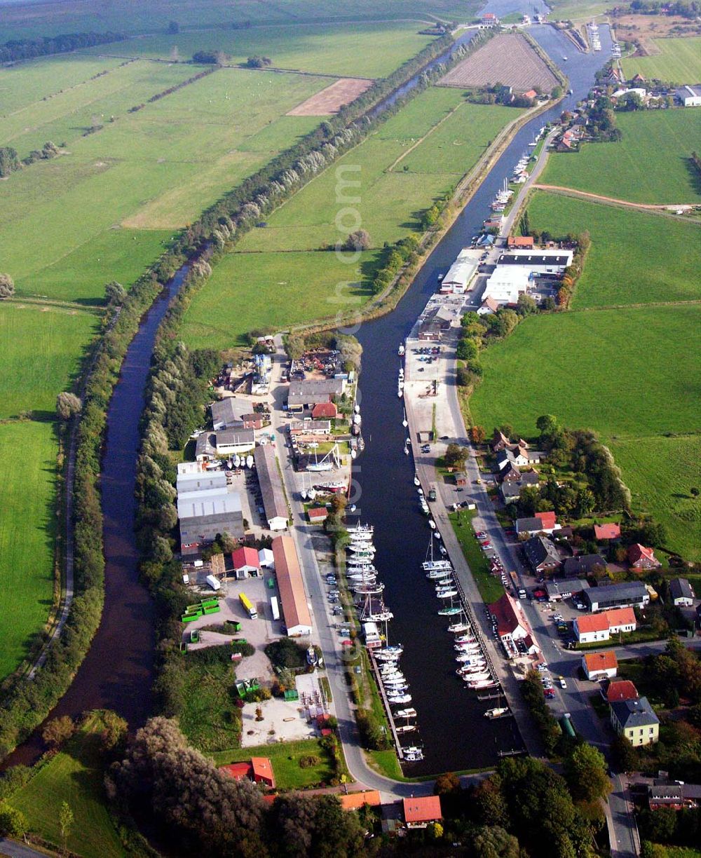 Varel from above - 18.10.2005 Varel; Varelerhafen, im heutigen Aussehen geht auf die Initiative des Großherzogtums Oldenburg von 1858 zurück. Der offene Zugang zur See sollte für den Handel genutzt werden. Ursprünglich wurde im Vareler Hafen wie in an deren Häfen Kaffe, Tabak, Tran, Zucker Baumwolle, Kohle und Vieh umgeschlagen. Nach verschiedenen Umbrüchen dient der Hafen heute vornehmlich der Fischerei, dem Bootsbau sowie den Wasserbootssport.