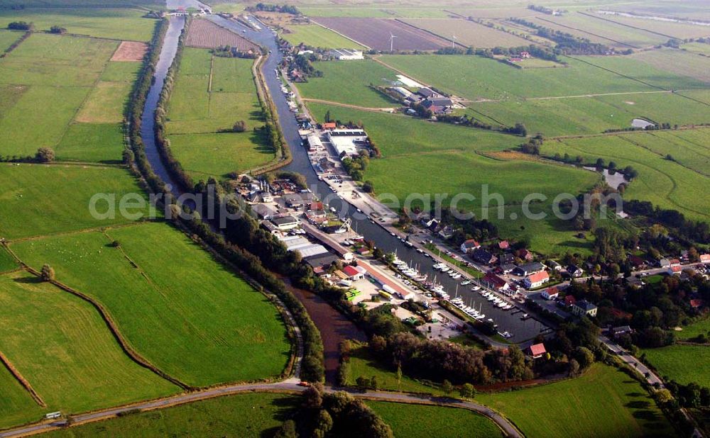 Varel from the bird's eye view: 18.10.2005 Varel; Varelerhafen, im heutigen Aussehen geht auf die Initiative des Großherzogtums Oldenburg von 1858 zurück. Der offene Zugang zur See sollte für den Handel genutzt werden. Ursprünglich wurde im Vareler Hafen wie in an deren Häfen Kaffe, Tabak, Tran, Zucker Baumwolle, Kohle und Vieh umgeschlagen. Nach verschiedenen Umbrüchen dient der Hafen heute vornehmlich der Fischerei, dem Bootsbau sowie den Wasserbootssport.